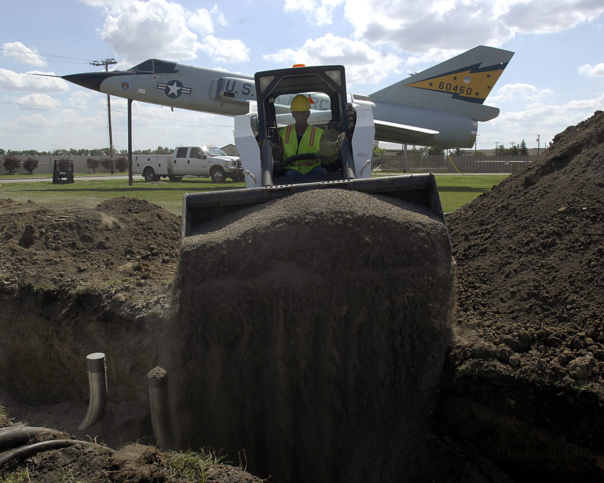 MINOT AIR FORCE BASE, N.D. — Construction worker and crane operator Dean Wiesenberger fills holes down Bomber Boulevard here Aug. 19. With the increase of facilities to the base, this renovation is to remedy and prevent an inefficient power capacity. (U.S. Air Force photo by Airman 1st Class Jesse Lopez)