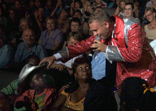 Senior Airman Nicholas Amari places a cowboy hat on Elicia Ferguson, 3, during a live performance by Tops in Blue at the Charleston Performing Arts Center Aug. 30. More than 2,400 people attended the Tops in Blue performance Saturday night. Elicia is the daughter of Staff Sgt. Maurice Ferguson, 315th Aircraft Maintenance Squadron. (U.S. Air Force photo/Airman 1st Class Timothy Taylor)