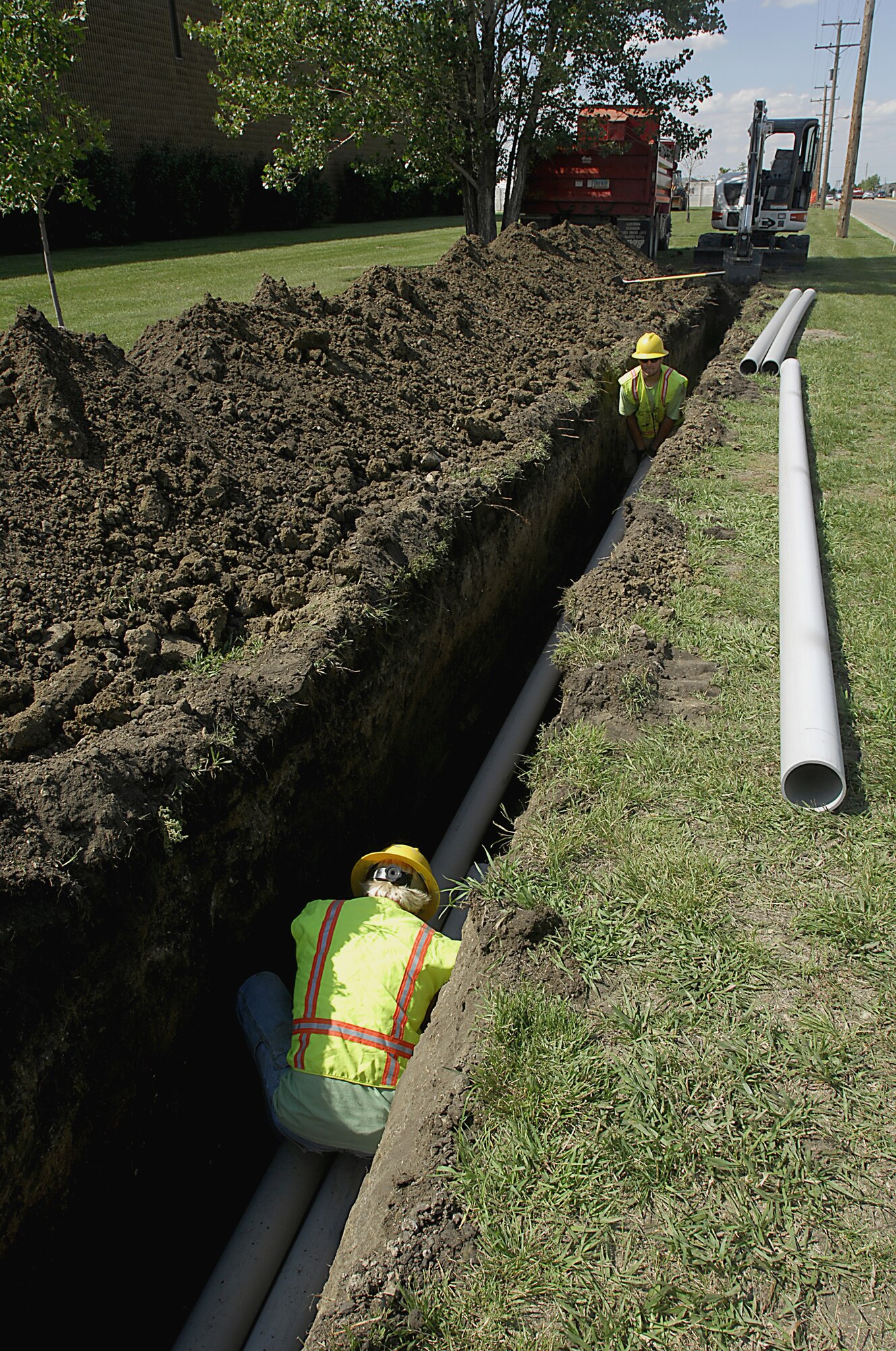 MINOT AIR FORCE BASE, N.D. — Construction workers Jeremy Bickel and Jared Portra replace the piping along Bomber Boulevard here Aug. 19. This overhaul is to replace the deteriorating overhead electrical distribution system, increasing the electrical capacity feed to the new dorms and Missile Wing complex. (U.S. Air Force photo by Airman 1st Class Jesse Lopez)