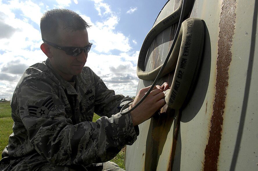 MINOT AIR FORCE BASE, N.D. — Senior Airman Havan Cherry, 5th Civil Engineer Squadron explosive ordnance disposal journeyman, places a composition C-4 plastic explosive during an EOD training exercise here Aug. 22. EOD have monthly training exercises comprised of various scenarios to help maintain their skills. (U.S. Air Force photo by Airman 1st Class Jesse Lopez)