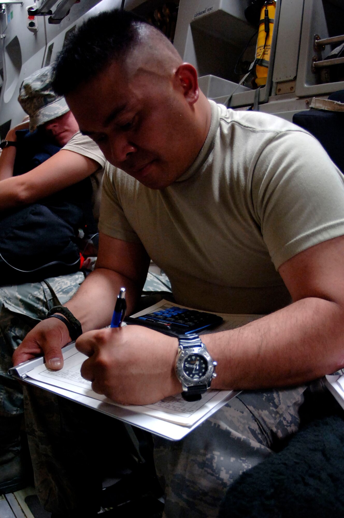 Staff Sgt. Audy Cayanan from Travis Air Force Base, Calif., fills out shipping documents while flying in C-17 Globemaster III Aug. 31. Sergeant Cayanan, along with other personnel, equipment and medical supplies on the aircraft were redirected from Beaumont, Texas, to Altus AFB, Okla., to reposition assets for Hurricane Gustav's landfall. (U.S. Air Force photo/Staff Sgt. Joseph L. Swafford Jr.)