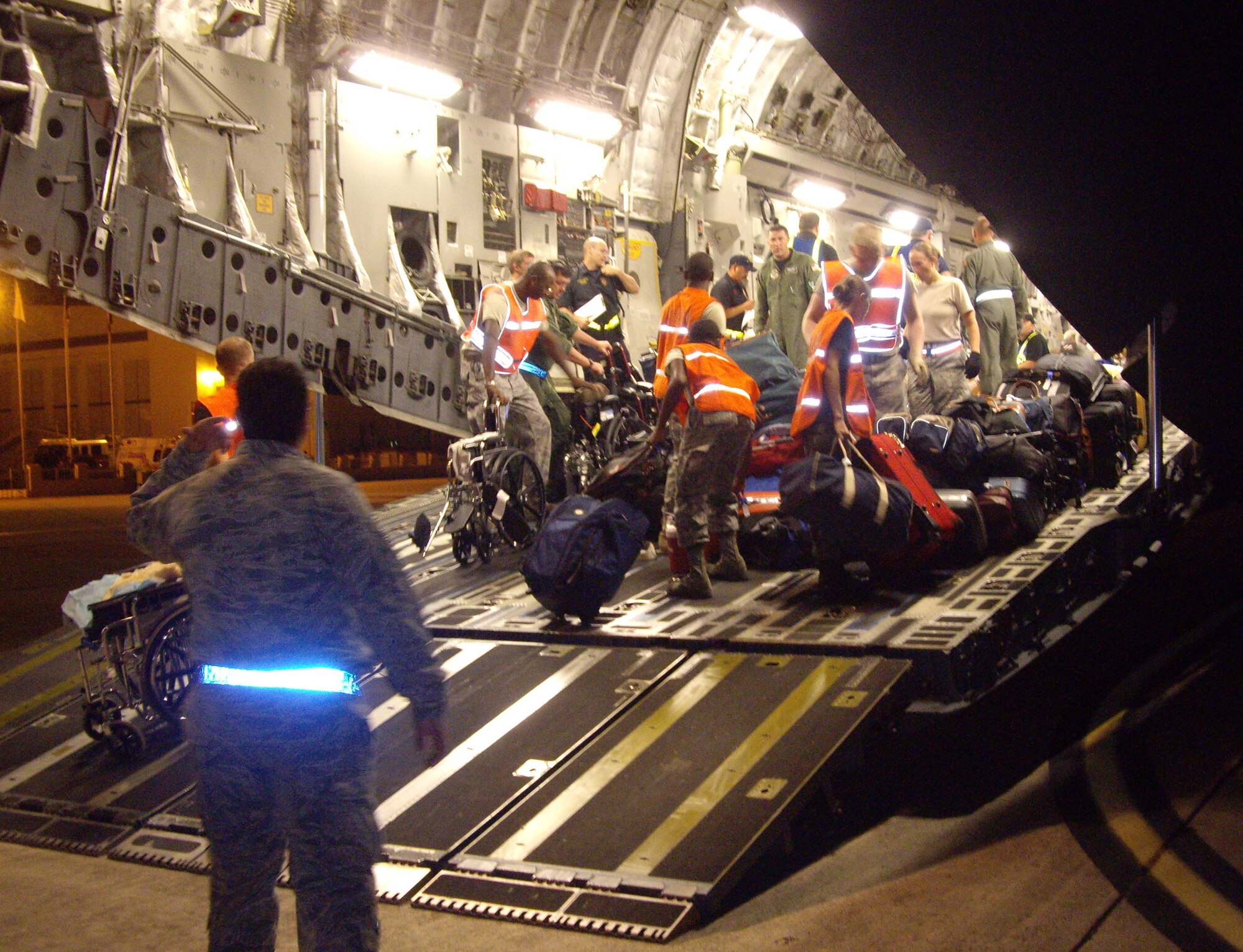 Medical personnel transport special needs patients from Beaumont, Texas, off a C-130 Hercules at Port San Antonio Aug. 30.  59th Medical Wing personnel helped move 247 Hurricane Gustav evacuees off aircraft and load them onto transport vehicles for destinations throughout San Antonio. (U.S. Air Force photo/Master Sgt. David Hunter)