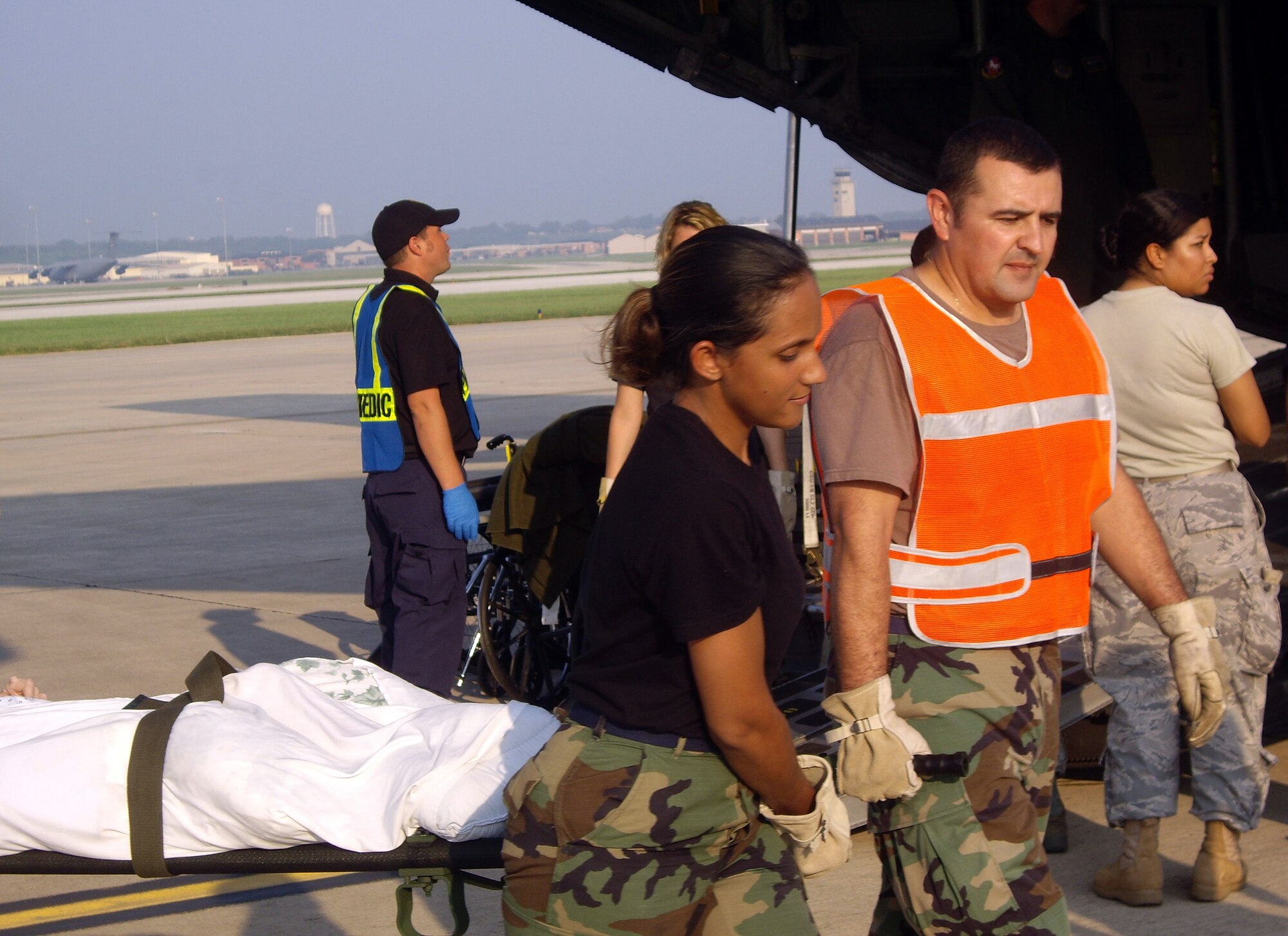 Staff Sgt. Nicole Johnson (left) and Tech. Sgt. Warren Lucero, both from the 59th Orthopedic and Rehabilitation Squadron, transport a patient from a C-130 Hercules Aug. 30 at Port San Antonio.  More than 240 special needs patients from Beaumont, Texas, were evacuated to San Antonio as Hurricane Gustav approached.  (U.S. Air Force photo/Master Sgt. David Hunter)