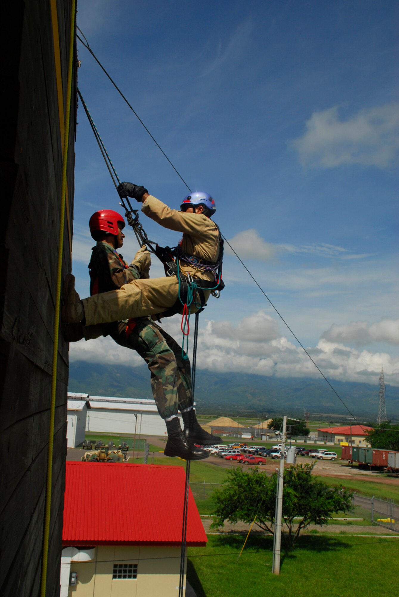 SOTO CANO AIR BASE, Honduras - Herberth Gaekel, JTF-Bravo fire inspector (right), displays how to perform a rescue operation while repelling. The Joint Task Force-Bravo fire department trained with Honduran Air Force and local fire fighters Aug. 25-28 on activities that varied from land navigation to rescue operations. (U.S. Air Force photo by Staff Sgt. Joel Mease)