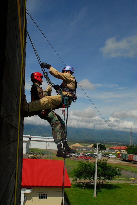 SOTO CANO AIR BASE, Honduras - Herberth Gaekel, JTF-Bravo fire inspector (right), displays how to perform a rescue operation while repelling. The Joint Task Force-Bravo fire department trained with Honduran Air Force and local fire fighters Aug. 25-28 on activities that varied from land navigation to rescue operations. (U.S. Air Force photo by Staff Sgt. Joel Mease)