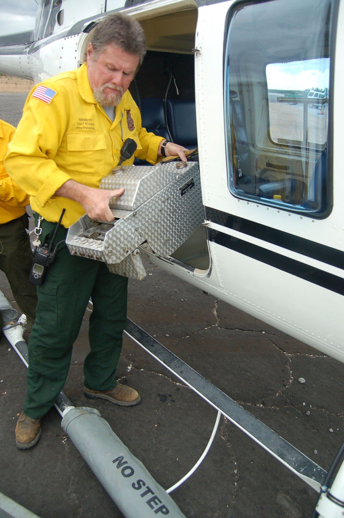 EGLIN AIR FORCE BASE, Fla. -- Roger Kennedy, Eglin fire management specialist, installs an aerial fire ignition dispenser device in a helicopter during a prescribed burn on the Eglin reservation.  U.S. Air Force photo by Jerron Barnett