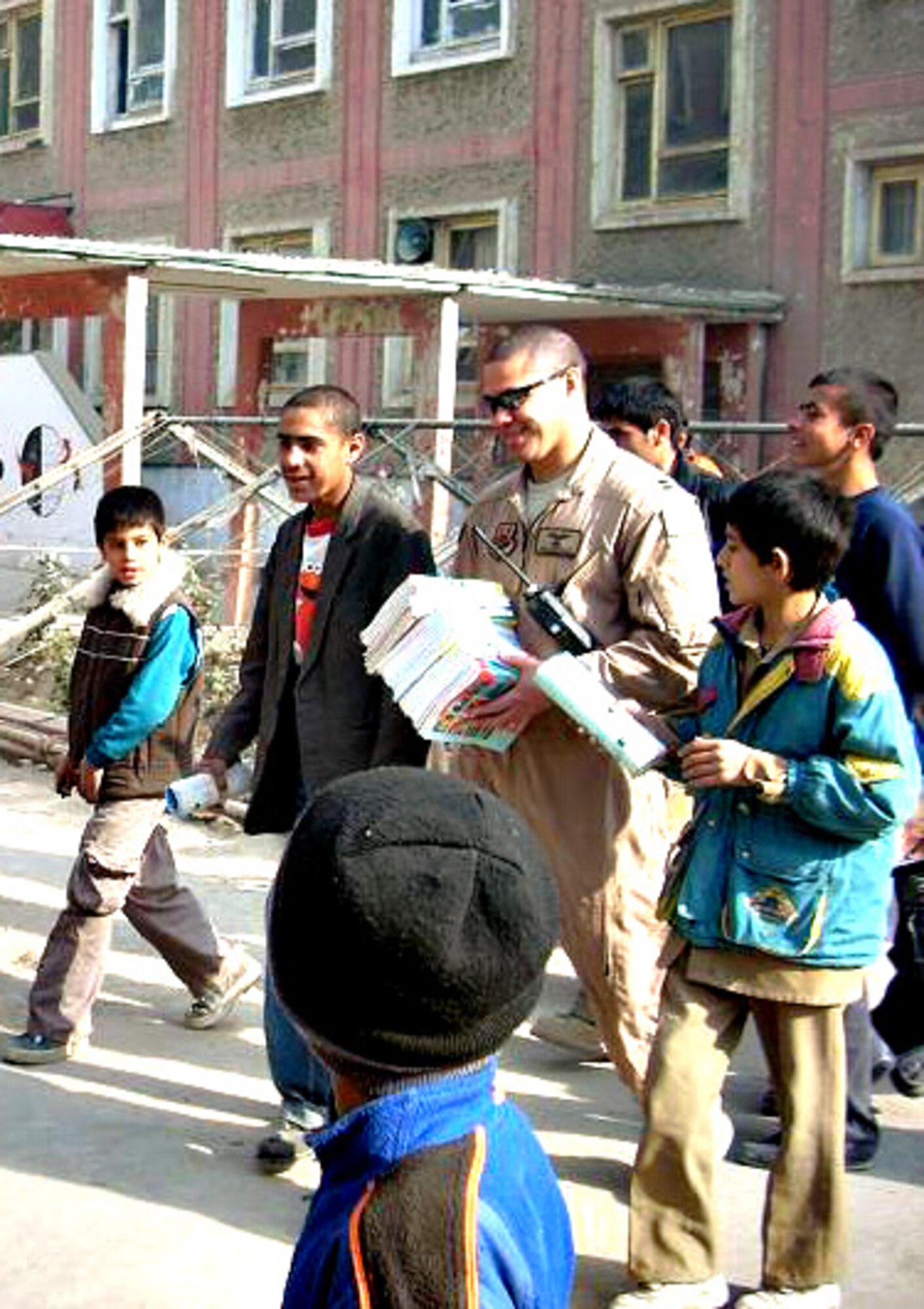 Capt. Michael Morales passing out school supplies to some of the 10,000 students at an Afghanistan all boys school. (Photo courtesy of Capt. Morales)