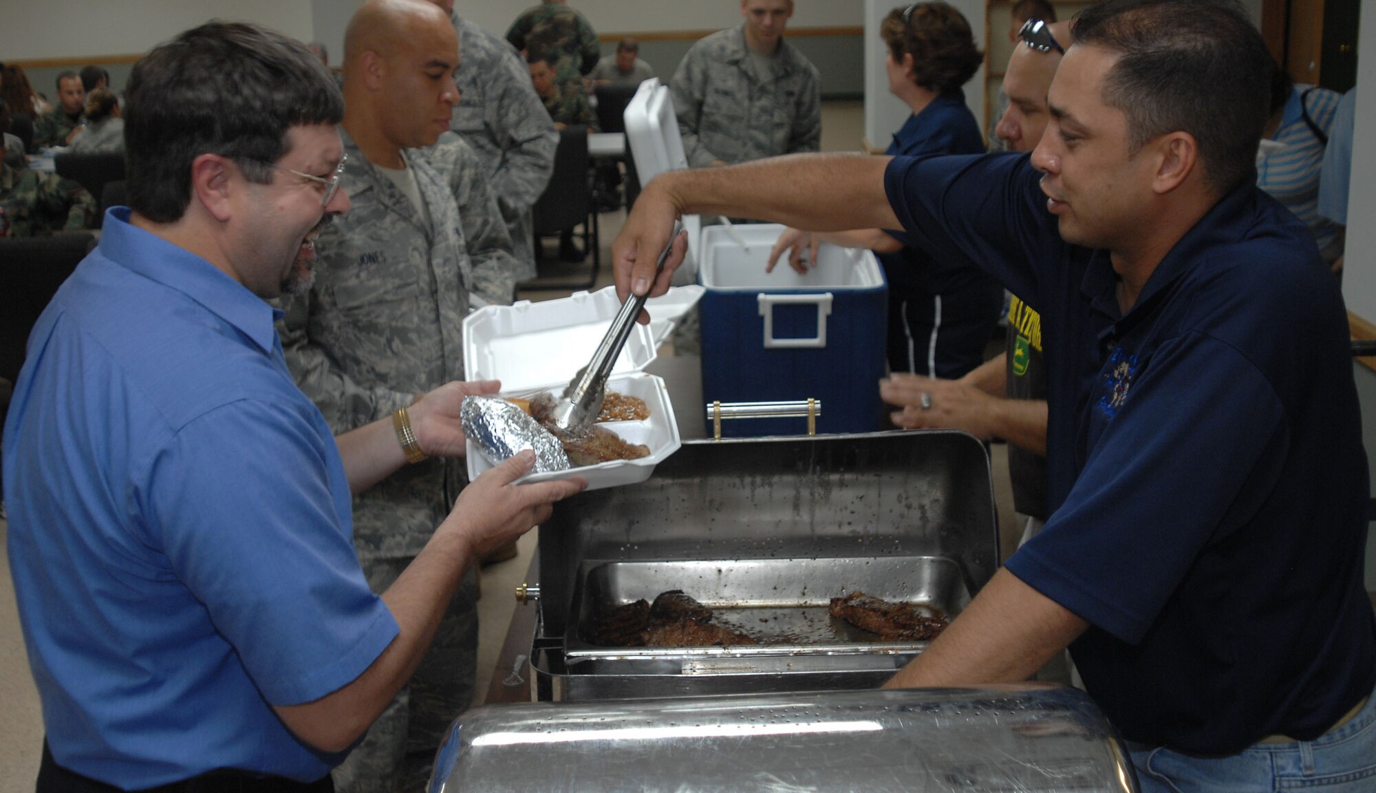 CANNON AIR FORCE BASE, N.M.- Master Sgt. Todd Christman, 27th Special Operations Civil Engineer Squadron, serves Tim Farmer, 27th SOCES, his share of steak at the First Sergeants' Steak Sale Aug. 22. The annual luncheon was attended by more than 100 people. (U.S. Air Force photo/ Airman Maynelinne De La Cruz)