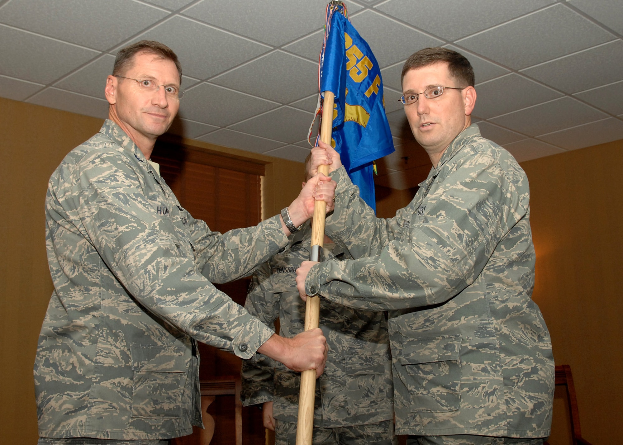 Col. Charles Hunter, 355th Mission Support Group commander, passes the guideon to Lt. Col. John Landolt III, becoming the new 355th Force Support commander here Aug. 28. The 355th Mission Support Squadron and the 355th Services Squadron officially became the 355th Force Support Squadron after an activation ceremony Aug. 28 at the O’ Club. (US Air Force Photo By:  Senior Airman Jacqueline Romero)