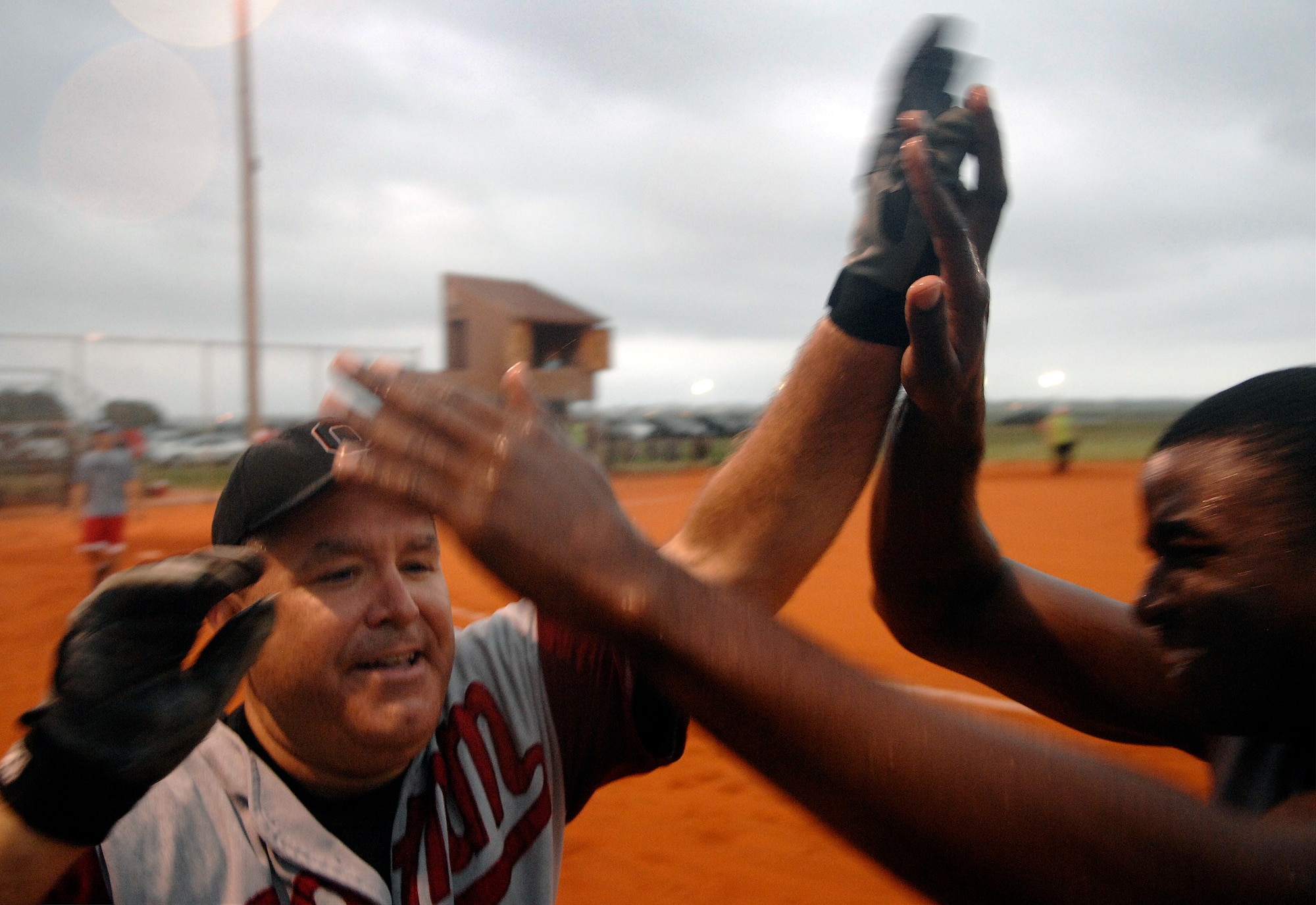 LANGLEY AIR FORCE BASE, Va. -- Lt. Col Jonathan Sutherland,1st Communications Squadron commander, is high-fived by Staff Sgt. Nicholas Henderson after scoring a run during the softball championship game against 1st Equipment Maintenance Squadron Aug. 28. The 1st CS handed 1st EMS its first loss of the year, 18-15, in the finale. (U.S. Air Force photo/Senior Airman Vernon Young)
