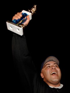 LANGLEY AIR FORCE BASE, Va. -- Staff Sgt. Jaime Torres, 1st Communications Squadron, holds his championship trophy in the air after helping 1st CS defeat of the 1st Equipment Maintenance Squadron in the championship game, Aug. 28. The 1st CS handed 1st EMS its first loss of the year, 18-15.   (U.S. Air Force photo/Senior Airman Vernon Young)