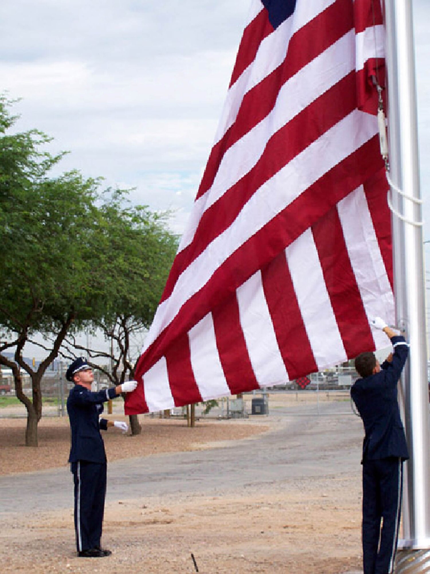Members of the Davis-Monthan Honor Guard Team conducted a flag raising ceremony Aug. 13 for the employees of the H. Wilson Sundt Generating Station. About 25 power plant employees attended the ceremony along with members of System Operations, watching from a stairwell at the Service Center. The new flag pole was installed early this month in front of the power plant at TEP's Irvington Campus as part of an ongoing beautification effort in commemoration of the plants 50th anniversary celebration. (Courtesy photo)
