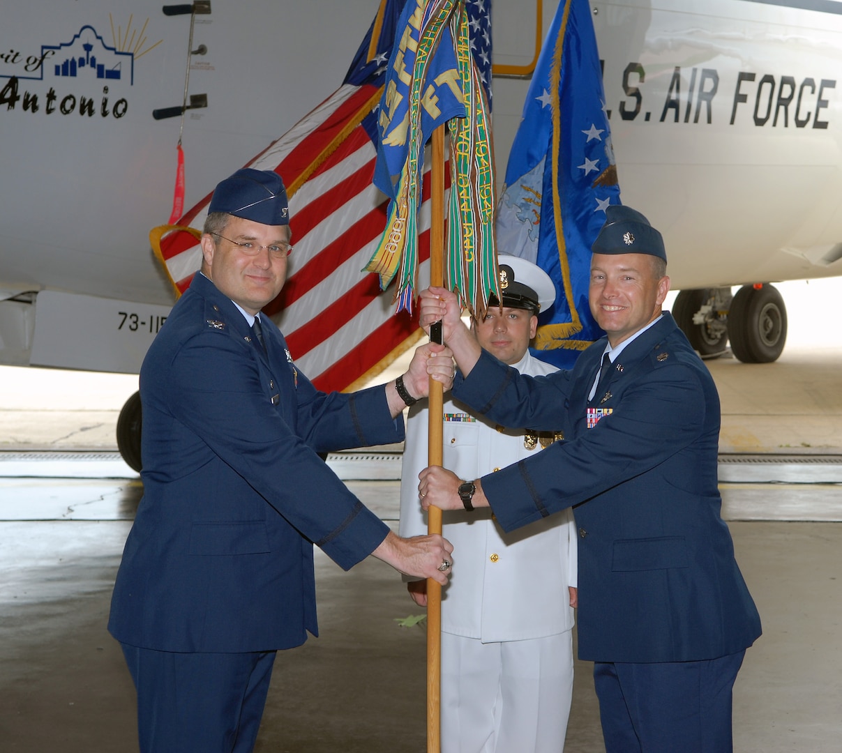 Col. Ronald Buckley (left), 12th Operations Group commander, passes command of the 562nd Flying Training Squadron to Lt. Col. Peter Deitschel during a change of command ceremony Aug. 29. The 562nd FTS recently began phasing out naval flight officer training, and the outgoing commander, Navy Cmdr. John Radka, is the last U.S. Navy officer to command the 562nd. (U.S. Air Force photo by Don Lindsey)