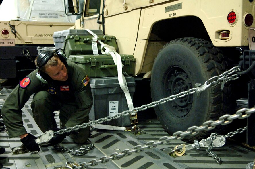Aboard a a C-17 Globemaster III en route to Altus Air Force Base, Okla., Staff Sgt. Jeff Austin, a C-17 loadmaster, tightens the chains on a forklift. The equipment, medical supplies and personnel were redirected from Beaumont, Texas, to Altus AFB to reposition assets in preperation for Hurricane Gustav's landfall.  (U.S. Air Force photo by Staff Sgt. Joseph L. Swafford Jr.)