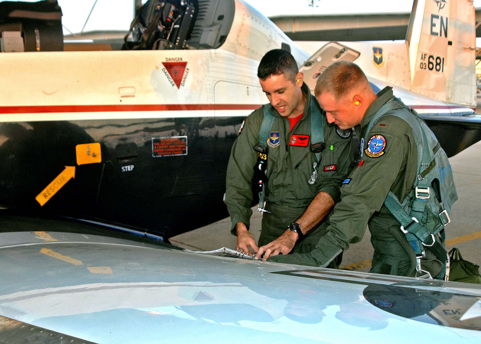 Capt. Chris Breffitt, left, an instructor with the 89th Flying Training Squadron, and student pilot 2nd Lt. Jeremy Curbey go through a pre-flight checklist Aug. 29 as the first class of the Euro-NATO Joint Jet Pilot Training Program took to the air in the T-6A Texan II. The aircraft began arriving in January, and about 70 will replace the program's aging T-37 Tweet fleet. (U.S. Air Force photo/Lou Anne Sledge)