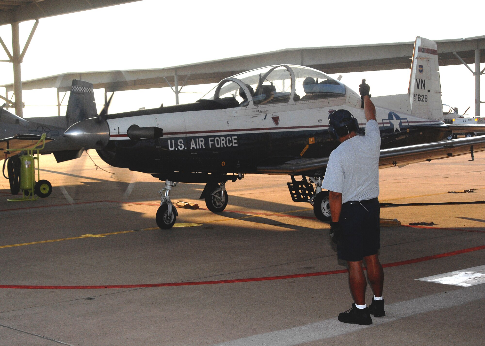 A Lier Siegler Services, Inc., crew chief gives a thumbs up to the aircrew of the first T-6A Texan II student training sortie Aug. 29 at the 80th Flying Training Wing. About 70 Texan IIs will replace the venerable T-37 Tweet. Instrucotr Pilot Capt. Chris Breffitt and student pilot 2nd Lt. Jeremy Curbey ushered in the new era of training with the first student training flight. (U.S. Air Force photo/Lou Anne Sledge)