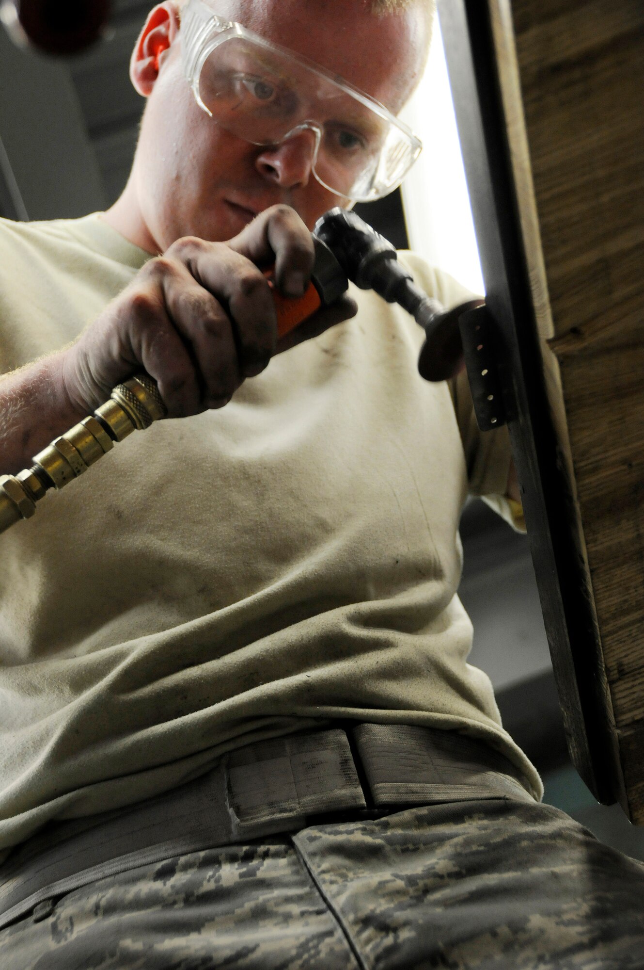 Staff Sgt. Ben Beermann, 379th Expeditionary Maintenance Squadron, Fabrication Flight, smoothes the edges of a patch he created Sep. 1, 2008, at an undisclosed air base in Southwest Asia. Sergeant Beermann, grinds the corner, smoothing out the edge of the patch that will fix a crack in an E-8C Joint Surveillance and Target Attack Radar System (JSTARS) aircraft cowling.  The non-flush patch provides structural integrity and keeps the elements out.  He measured, cut, punched in rivet holes and then smoothed out all the rough edges before attaching the patch to the cowling.  The JSTARS platform provides an airborne battle management, command and control, intelligence, surveillance and reconnaissance platform supporting Operations Iraqi and Enduring Freedom and Joint Task Force-Horn of Africa.  Its primary mission is to provide theater ground and air commanders with ground surveillance to support attack operations and targeting that contributes to the delay, disruption and destruction of enemy forces.  Sergeant Beermann, a native of Dakota City, Neb., is deployed from Robins Air Force Base, Ga.  (U.S. Air Force Base photo by Tech. Sgt. Michael Boquette/Released)