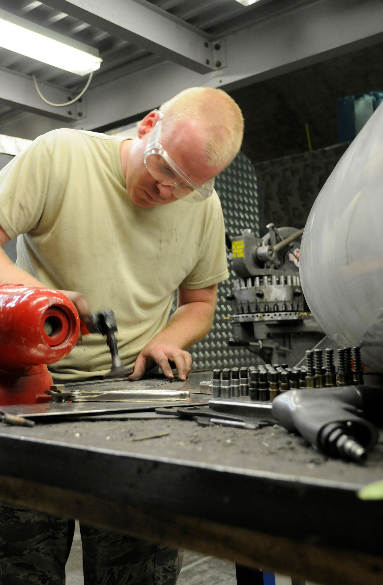 Staff Sgt. Ben Beermann, 379th Expeditionary Maintenance Squadron, Fabrication Flight, smoothes out rivet hole edges of a patch he created Sep. 1, 2008, at an undisclosed air base in Southwest Asia. Sergeant Beermann, grinds the corner, smoothing out the edge of the patch that will fix a crack in an E-8C Joint Surveillance and Target Attack Radar System (JSTARS) aircraft cowling.  The non-flush patch provides structural integrity and keeps the elements out.  He measured, cut, punched in rivet holes and then smoothed out all the rough edges before attaching the patch to the cowling.  The JSTARS platform provides an airborne battle management, command and control, intelligence, surveillance and reconnaissance platform supporting Operations Iraqi and Enduring Freedom and Joint Task Force-Horn of Africa.  Its primary mission is to provide theater ground and air commanders with ground surveillance to support attack operations and targeting that contributes to the delay, disruption and destruction of enemy forces.  Sergeant Beermann, a native of Dakota City, Neb., is deployed from Robins Air Force Base, Ga.  (U.S. Air Force Base photo by Tech. Sgt. Michael Boquette/Released)