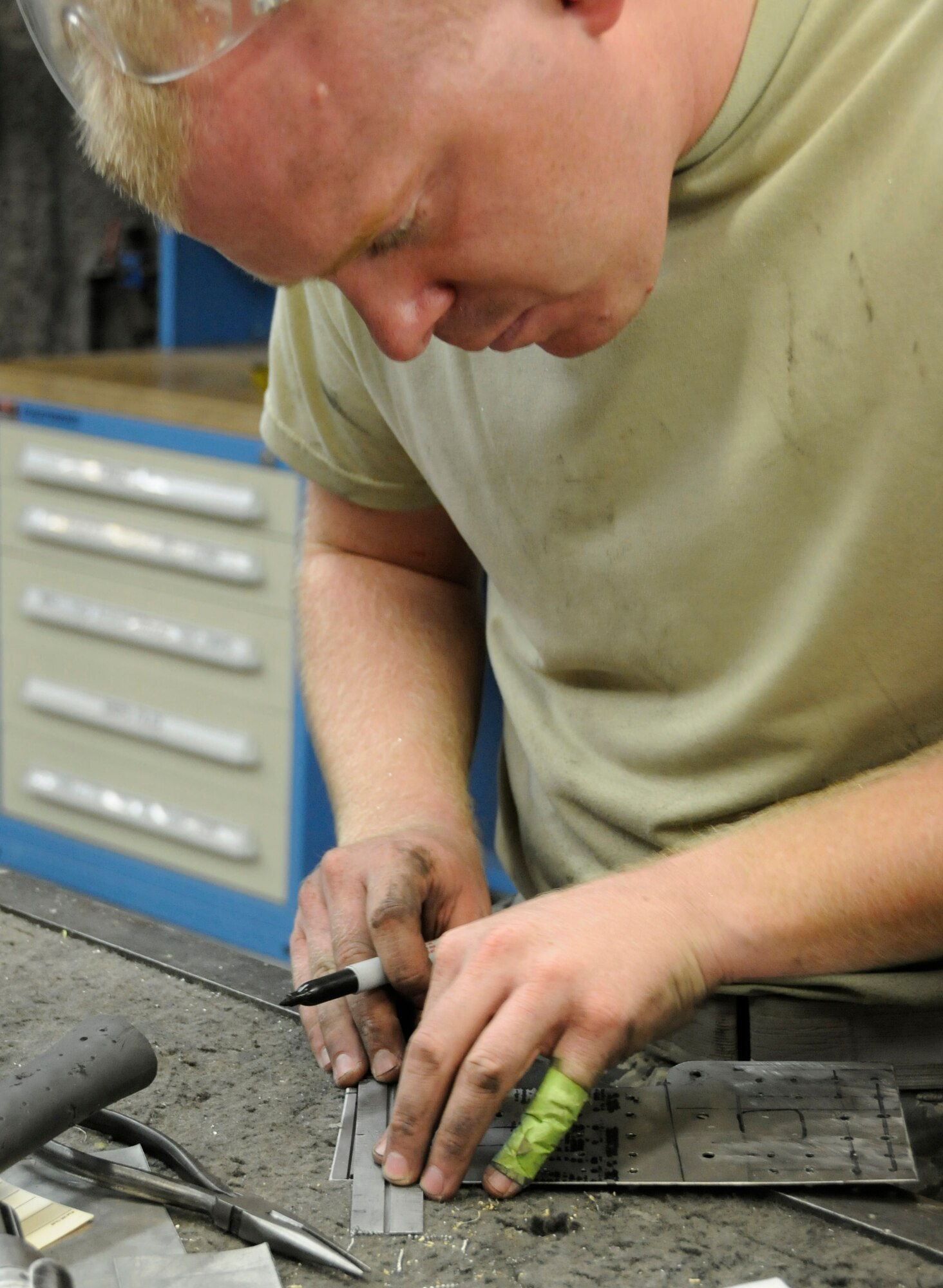 Staff Sgt. Ben Beermann, 379th Expeditionary Maintenance Squadron, Fabrication Flight, marks where to cut a patch he created Sep. 1, 2008, at an undisclosed air base in Southwest Asia. Sergeant Beermann, grinds the corner, smoothing out the edge of the patch that will fix a crack in an E-8C Joint Surveillance and Target Attack Radar System (JSTARS) aircraft cowling.  The non-flush patch provides structural integrity and keeps the elements out.  He measured, cut, punched in rivet holes and then smoothed out all the rough edges before attaching the patch to the cowling.  The JSTARS platform provides an airborne battle management, command and control, intelligence, surveillance and reconnaissance platform supporting Operations Iraqi and Enduring Freedom and Joint Task Force-Horn of Africa.  Its primary mission is to provide theater ground and air commanders with ground surveillance to support attack operations and targeting that contributes to the delay, disruption and destruction of enemy forces.  Sergeant Beermann, a native of Dakota City, Neb., is deployed from Robins Air Force Base, Ga.  (U.S. Air Force Base photo by Tech. Sgt. Michael Boquette/Released)