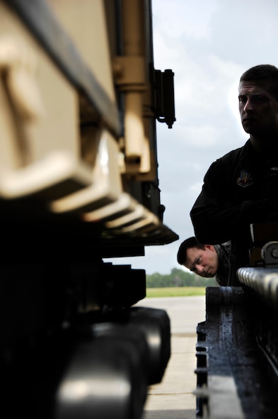 MOODY AIR FORCE BASE, Ga. -- An observer sneaks a quick peek as Senior Airman Geoff Koppel, 71st Rescue Squadron loadmaster, observes the transfer of a Rescue Operations Center pallet onto a 71st RQS C-130 Hercules here Sept. 1. The ROC provides command, control and communication assets to deployed rescue forces. The aircraft and its team were not deployed, but the base remains ready to assist further hurricane response efforts as the season progresses. (U.S. Air Force photo by Tech. Sgt. Parker Gyokeres)