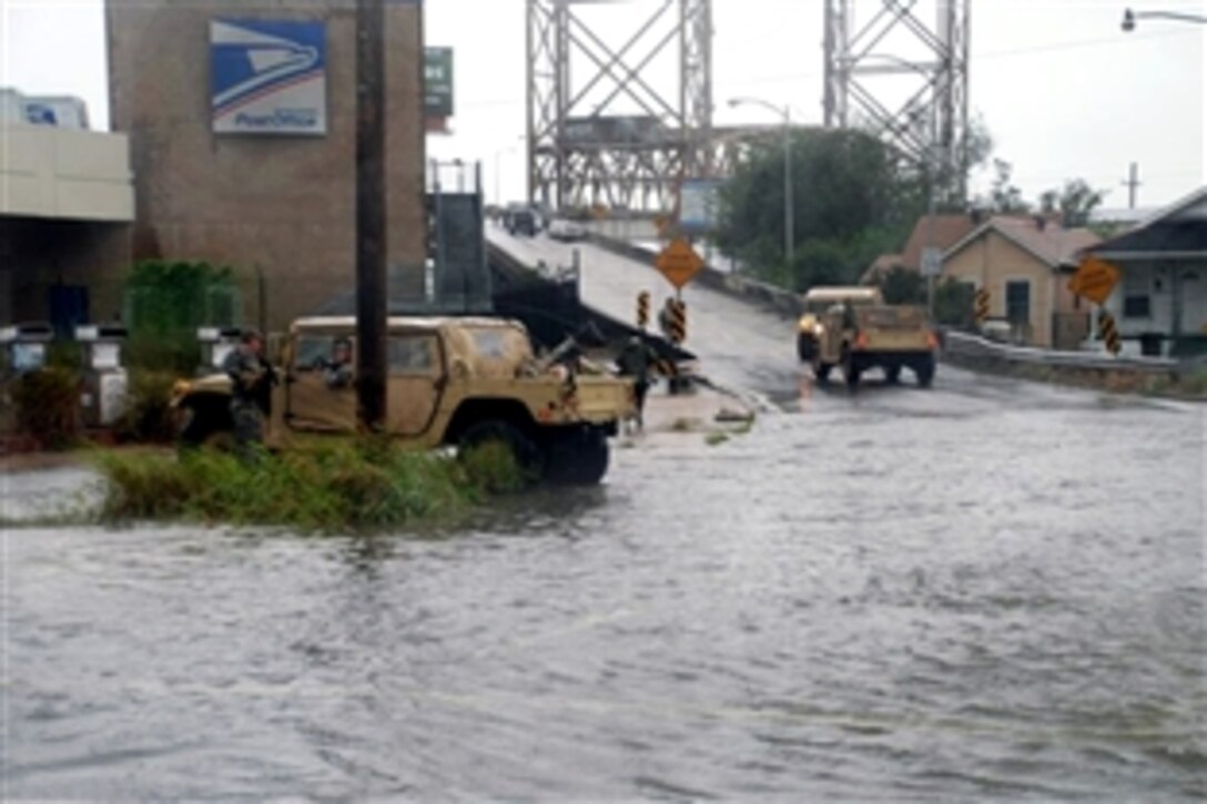 Members of the Louisiana National Guard set up a road block in the upper 9th Ward of New Orleans as water in the Industrial Canal starts to overtop the levees and pour into the city, Sept. 1, 2008. 