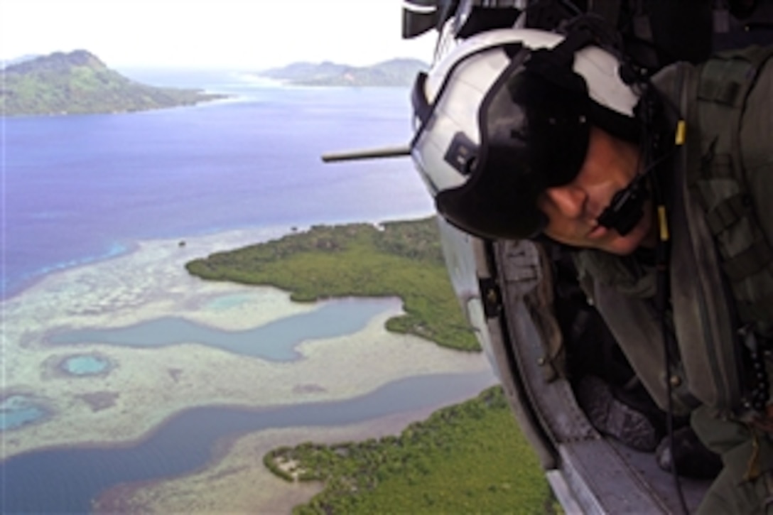 U.S. Navy Petty Officer 2nd Class Travis Nelson, assigned to Helicopter Combat Support Squadron 21, looks out over the water of Micronesia while flying in a MH-60S Sea Hawk helicopter during a Pacific Partnership 2008 mission, Aug. 31, 2008. Pacific Partnership is a four-month humanitarian mission to Southeast Asia intended to build collaborative partnerships by providing engineering, civic, medical and dental assistance to the region. 