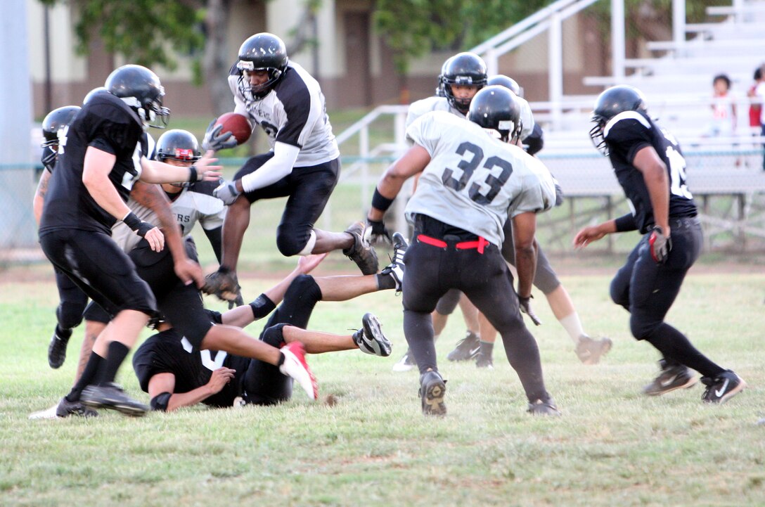 Timothy Johnson, Raiders running back, takes a flying leap over a Renegades defender, while rushing for yardage during a 2008 Intramural Football League game at Pop Warner Field Sept. 3.
