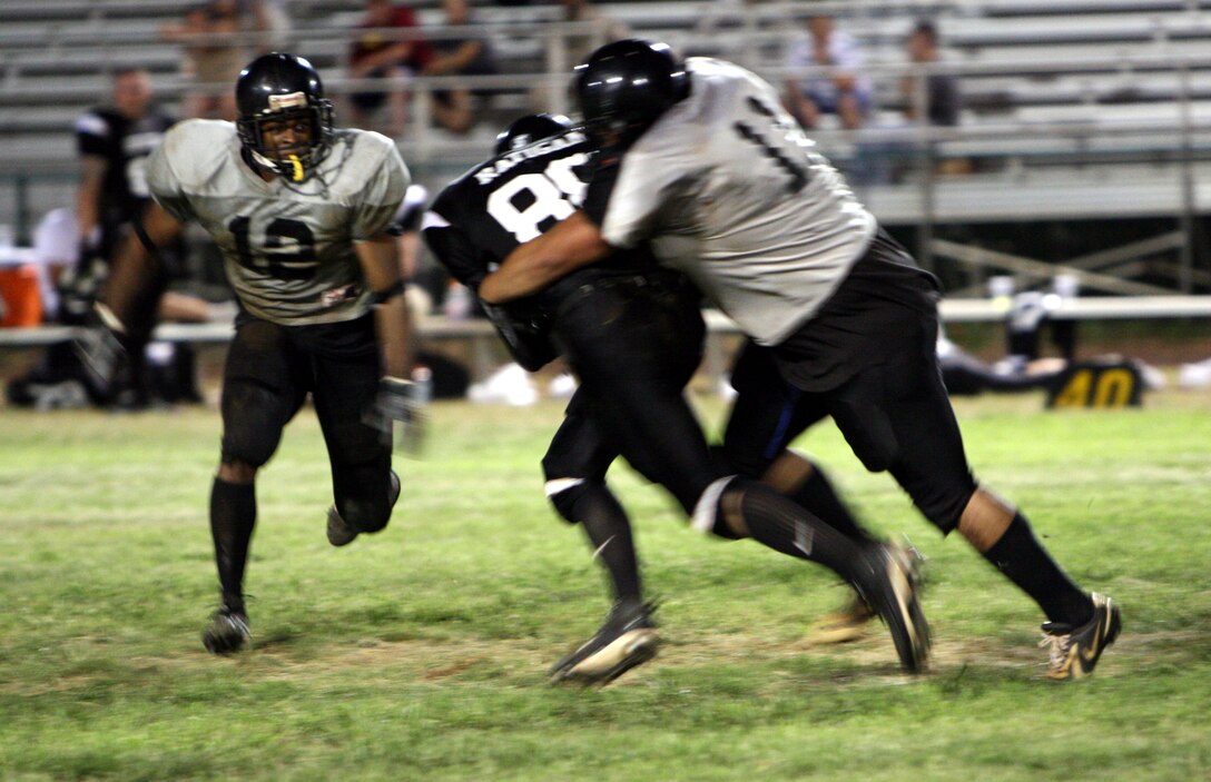 Royden Mokiao, Raiders linebacker, tackles Ryan Ratigan, Renegades quarterback, as DeShaun Brandy (left), Raiders safety, runs in for the assist during a 2008 Intramural Football League game at Pop Warner Field Sept. 3.