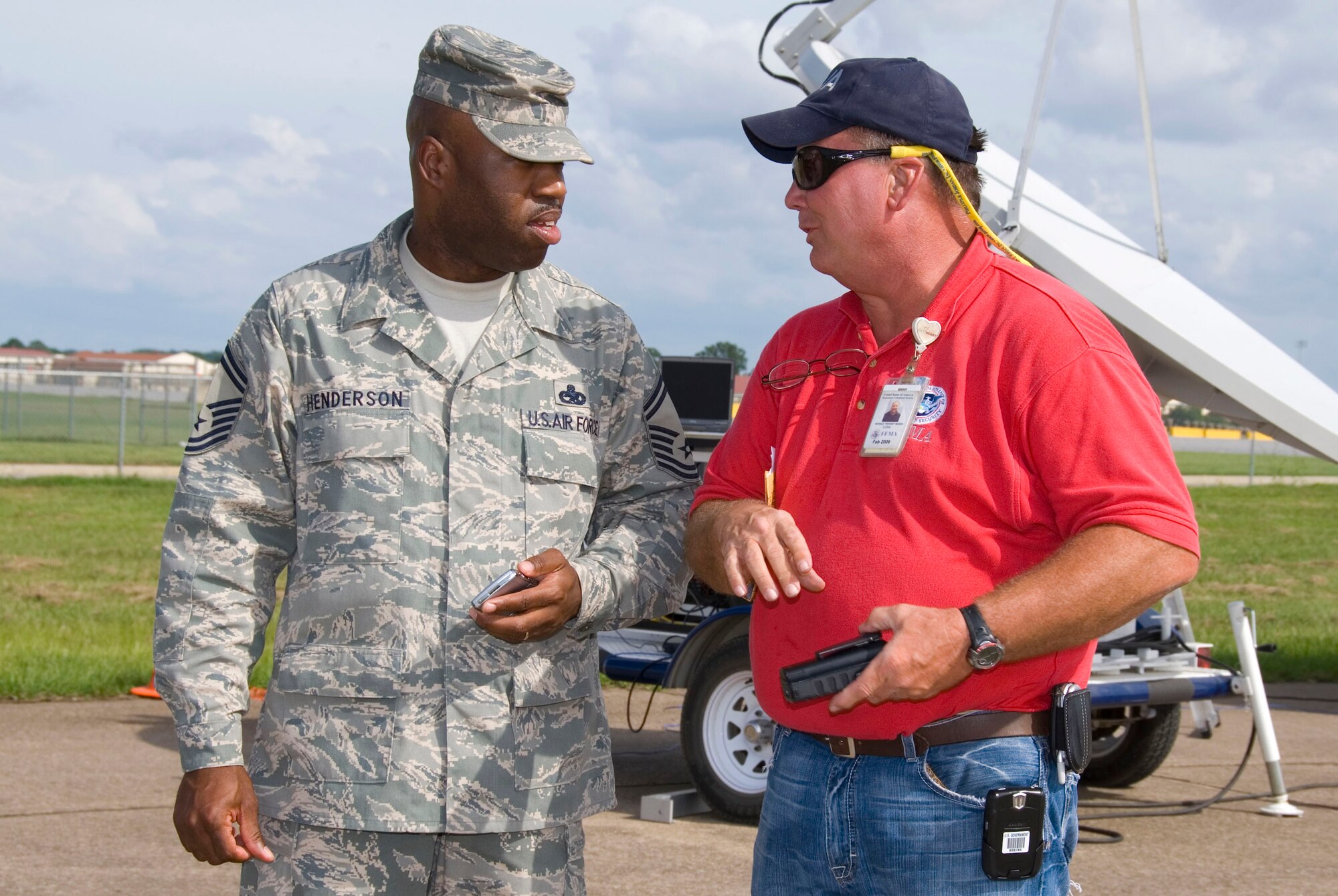 Senior Master Sgt. Terence Henderson, the Maxwell Air Force Base, Ala., Federal Emergency Management Agency liaison, talks with Ronnie Banes, a FEMA site manager, about staging efforts on the base flightline.  (U.S. Air Force photo/Jamie Pilcher)