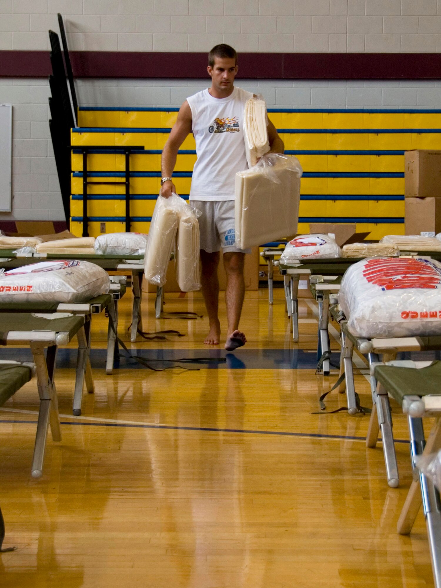 Jacob Weir, a contractor at Maxwell Air Force Base, Ala., sets up bedding Aug. 31 in the base gymnasium which serves as a temporary shelter for any evacuees arriving from the Gulf coast during Hurricane Gustav.  (U.S. Air Force photo/Jamie Pilcher)