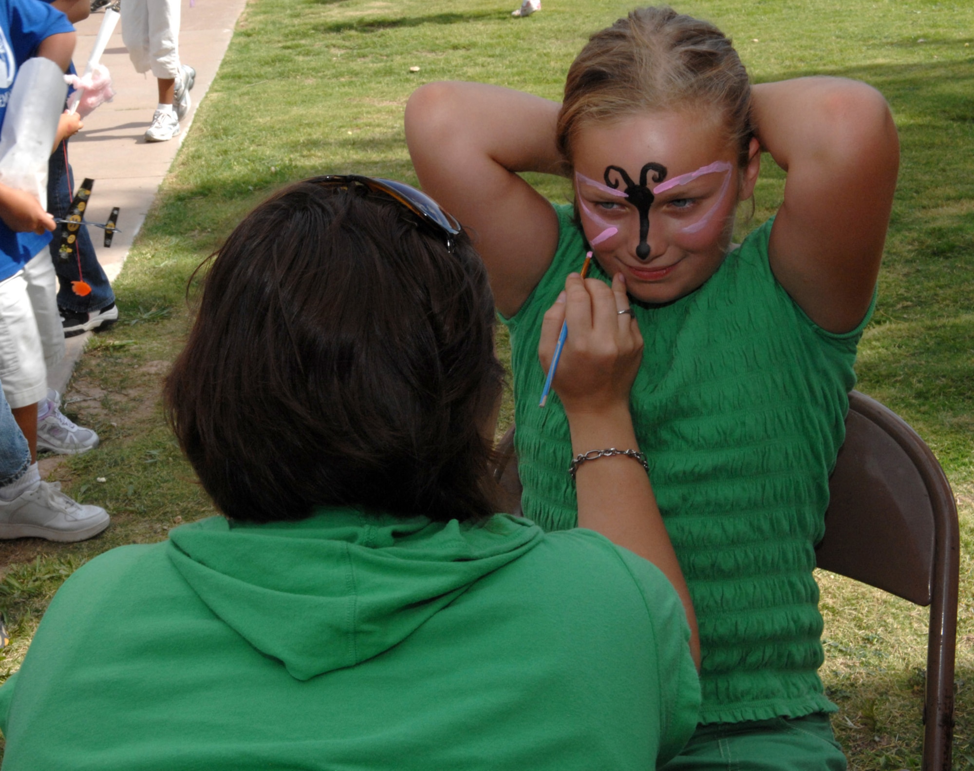 Anna, 9, daughter of Lt. Col. Steven Luczynski, 49th Operations Support Squadron, gets a butterfly painted on her face by volunteer, Senior Airman Tiffany Trojca, 49th Fighter Wing, at the Back to School Carnival at Holloman Air Force Base, N.M., August 29. More than 350 people attended the carnival that kicked off the new school year. (U.S. Air Force photo/Airman Sondra M. Escutia)