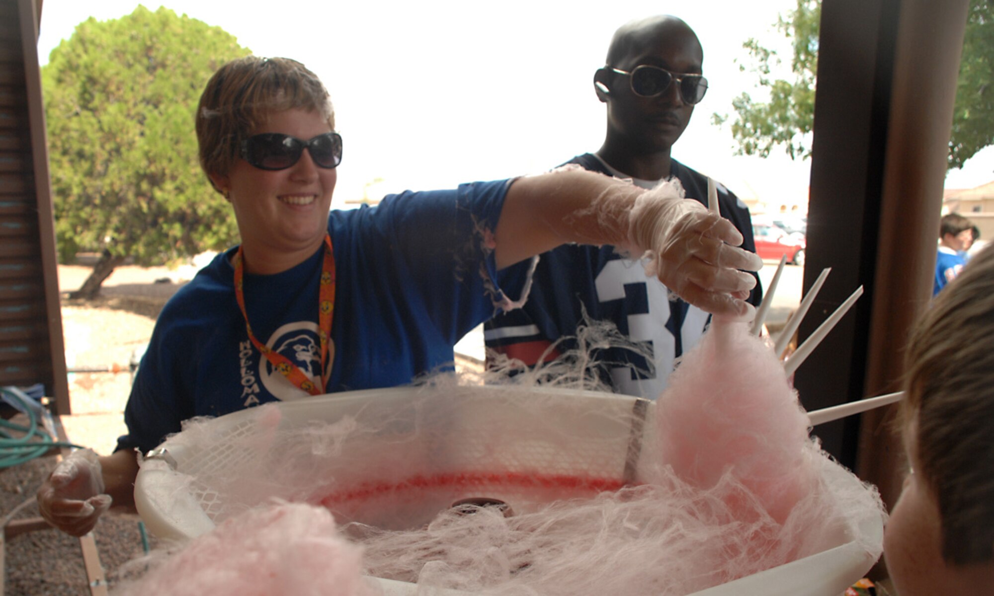 Tina Ray, Parent Teacher Organization treasurer, and her husband, Staff Sgt. Antwan Ray, 49th Aero Medical Dental Squadron, serve cotton candy during the Back to School Kid's Carnival at Holloman Air Force Base, N.M., Aug. 30. The carnival was held in celebration of the new school year. (U.S. Air Force photo/ Senior Airman Tiffany Trojca)