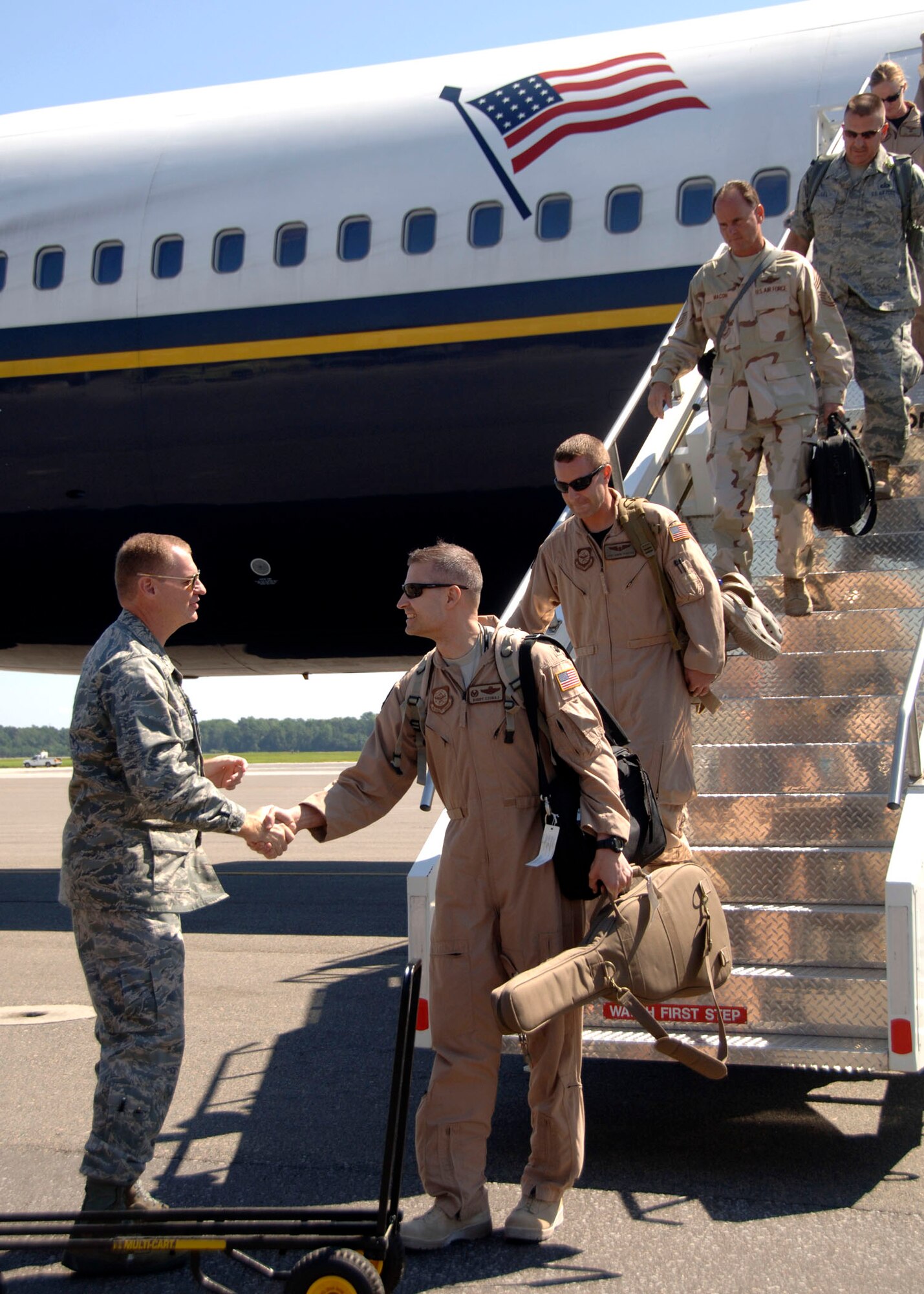 Col. John "Red" Millander greets Lt. Col. Norman "Buddy" Czubaj as the 14th Airlift Squadron makes their way off the plane after arriving to the Charleston AFB flightline Sept. 3. The 14 AS returned after a four-month deployment to Southwest Asia. Colonel Millander is the 437th Airlift Wing commander and Colonel Czubaj is the 14 AS commander.  (U.S. Air Force Photo/Airman 1st Class Cynthia Spalding)