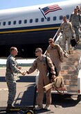 Col. John "Red" Millander greets Lt. Col. Norman "Buddy" Czubaj as the 14th Airlift Squadron makes their way off the plane after arriving to the Charleston AFB flightline Sept. 3. The 14 AS returned after a four-month deployment to the Middle East. Colonel Millander is the 437th Airlift Wing commander and Colonel Czubaj is the 14 AS commander. (U.S. Air Force Photo/Airman 1st Class Cynthia Spalding)
