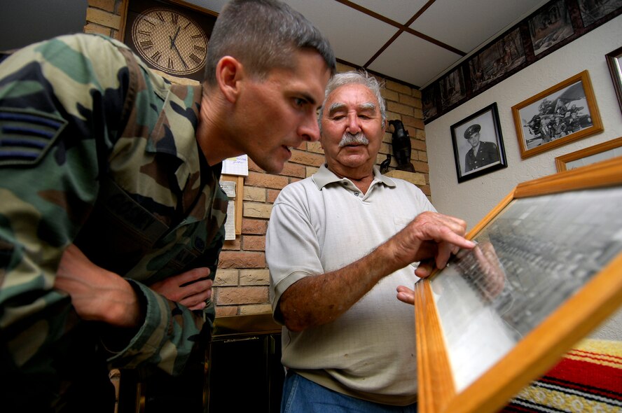 MINOT AIR FORCE BASE, N.D. – Elmer Wolf, a World War II veteran and true living legend, shows Staff Sgt. Dale Gosney, former member of the Minot AFB Living Legends group, a photo of his squadron during his time in the Army Air Corps. The Living Legends group began with the donation of Mr. Wolf’s service-dress uniform. (U.S. Air Force photo by Senior Airman Kelly Timney)