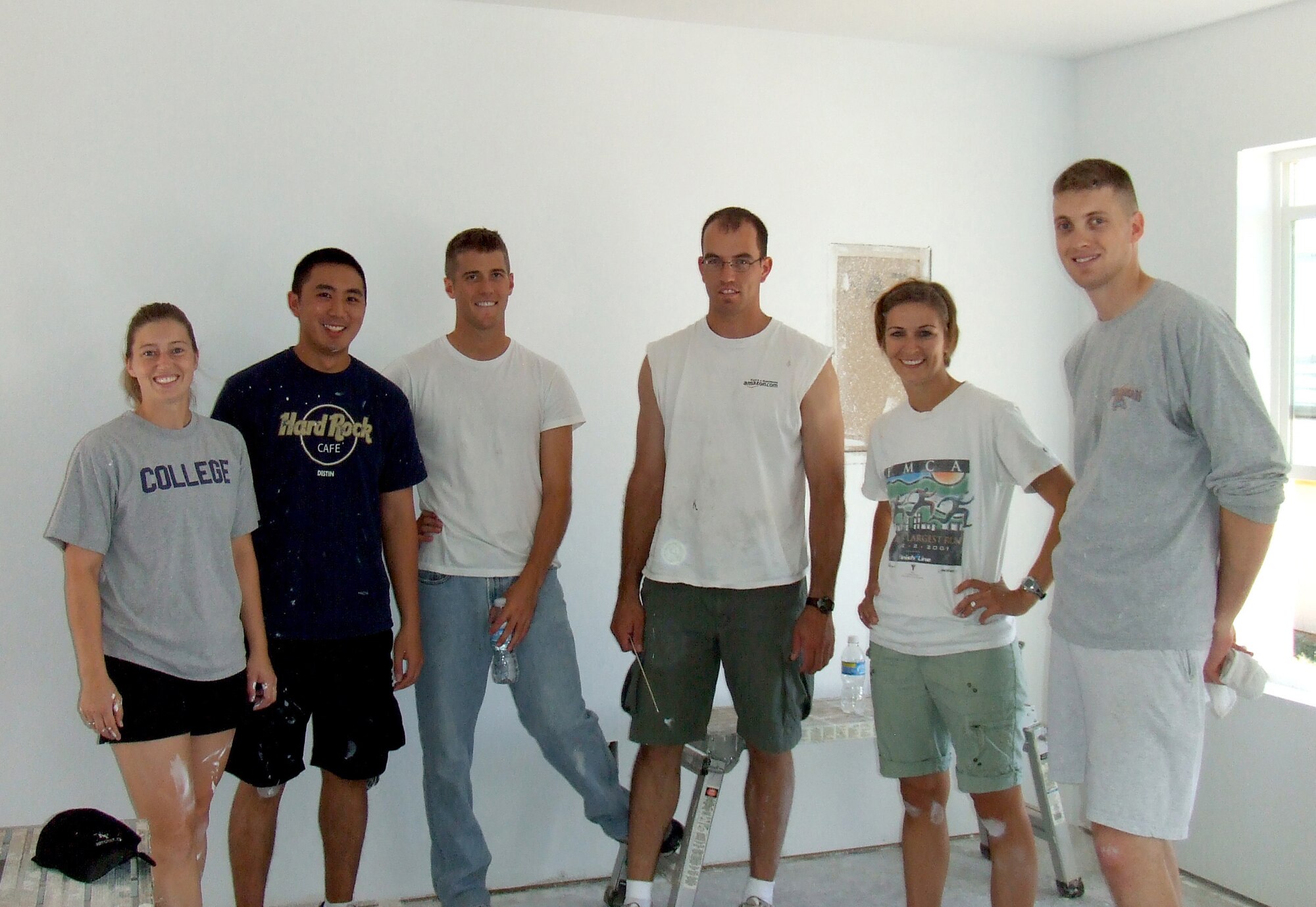 Members of the Company Grade Officer's Committee of Holloman Air Force Base, N.M., take a break from painting to pose for a photo, August 23. The members were volunteering for Otero County's Habitat for Humanity and spent much of their Saturday morning putting two coats of paint in every room of the Habitat house. The house will later be sold with no interest on the mortgage, making it affordable for a low-income family. (Photo provided)