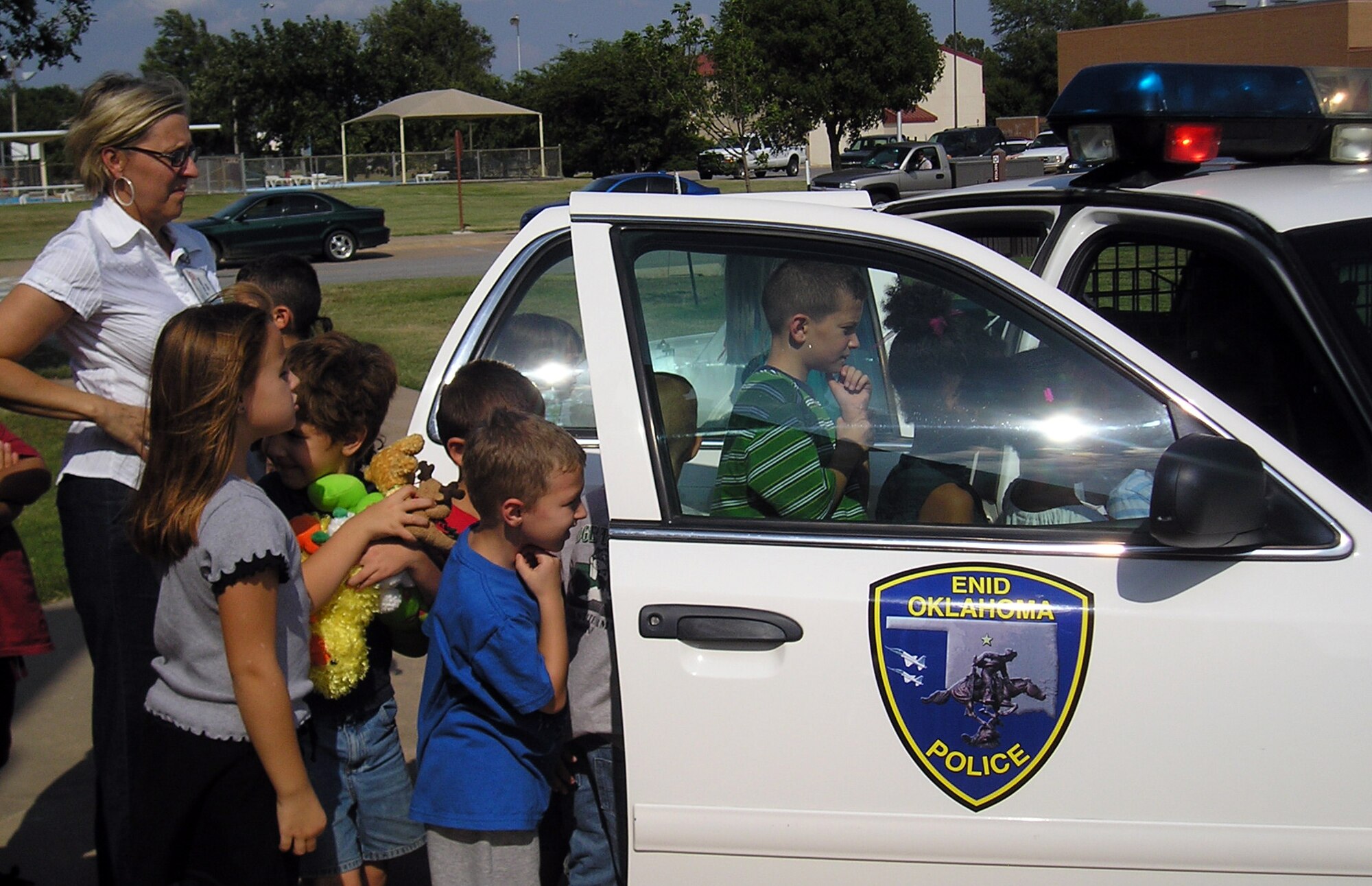 Children at the Vance School Age Program get a close-up view of the kind of police car James McFadden, a SAP counselor, will drive in his new career as an Enid police officer. He was known to the children in SAP as Mr. James during his two years working there. (Courtesy photo)