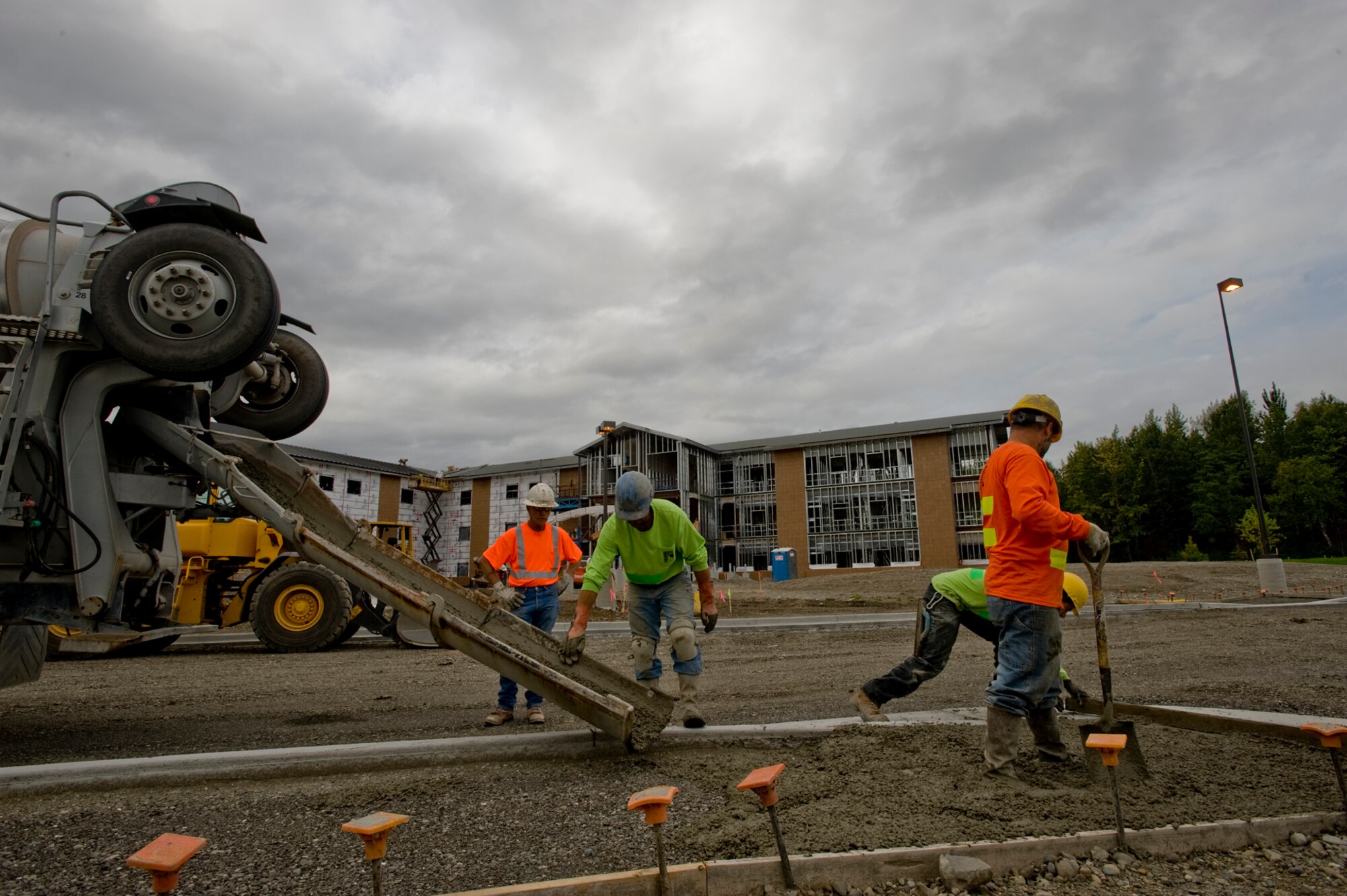 ELMENDORF AIR FORCE BASE, Alaska -- Members from Finishing Edge Concrete and Construction, lay down the foundation for a sidewalk in front of the new dorm  here Sept. 2. The new dorm project is being built by several different contract companies from the Anchorage community. The dorm is scheduled to be fully operational by mid-Febuary. (U.S. Air Force photo/Staff Sgt. Joshua Garcia)