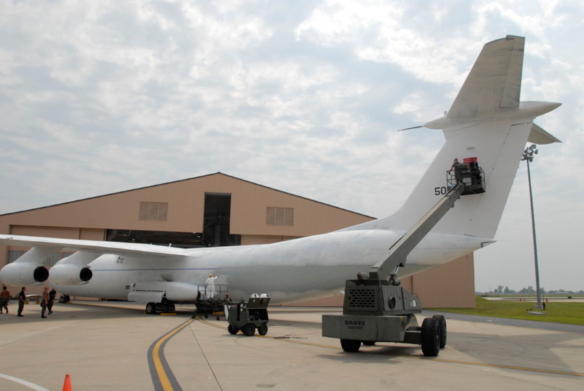 SCOTT AIR FORCE BASE, Ill. -- Illinois Air National Guardsman Master Sgt. Ray Wrezk, (lower left) applies grey paint to the fuselage of a C-141 cargo plane while Tech. Sgt. Lawrence Watts (upper right) details the U.S. flag on the tail. The maintenance squadron members of the 126th Air Refueling Wing are repainting the Starlifter to its original color scheme prior to the plane being put on permanent public display in the Scott Heritage Airpark. 
(US Air Force photo/Master Sgt. Ken Stephens)

