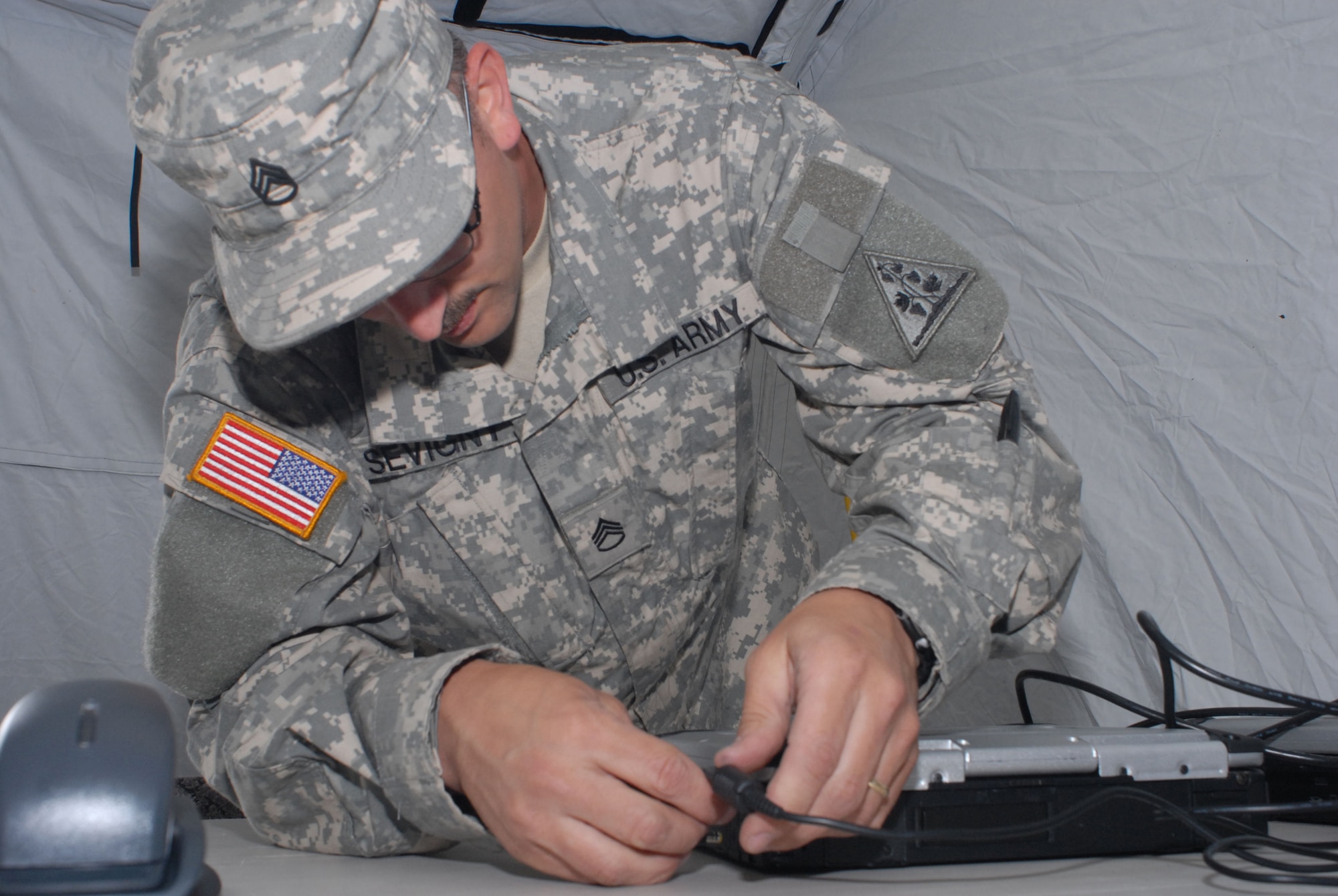 Army National Guardsman, Staff Sgt. Ted Sevigny, Joint Forces Headquarters, Hartford, Connecticut, connects a laptop to the Joint Incident Site Communication Capability (JISCC) system during the June 5, 2008 deployed training exercise at Camp Rell, Niantic, Connecticut.  Connecticut Air and Army National Guard units train together on deploying the JISCC equipment, which allows federal, military, state and local emergency services to coordinate disaster relief efforts with real-time communication. (U.S. Air Force photo by Staff Sgt. Nicholas A. McCorkle) 