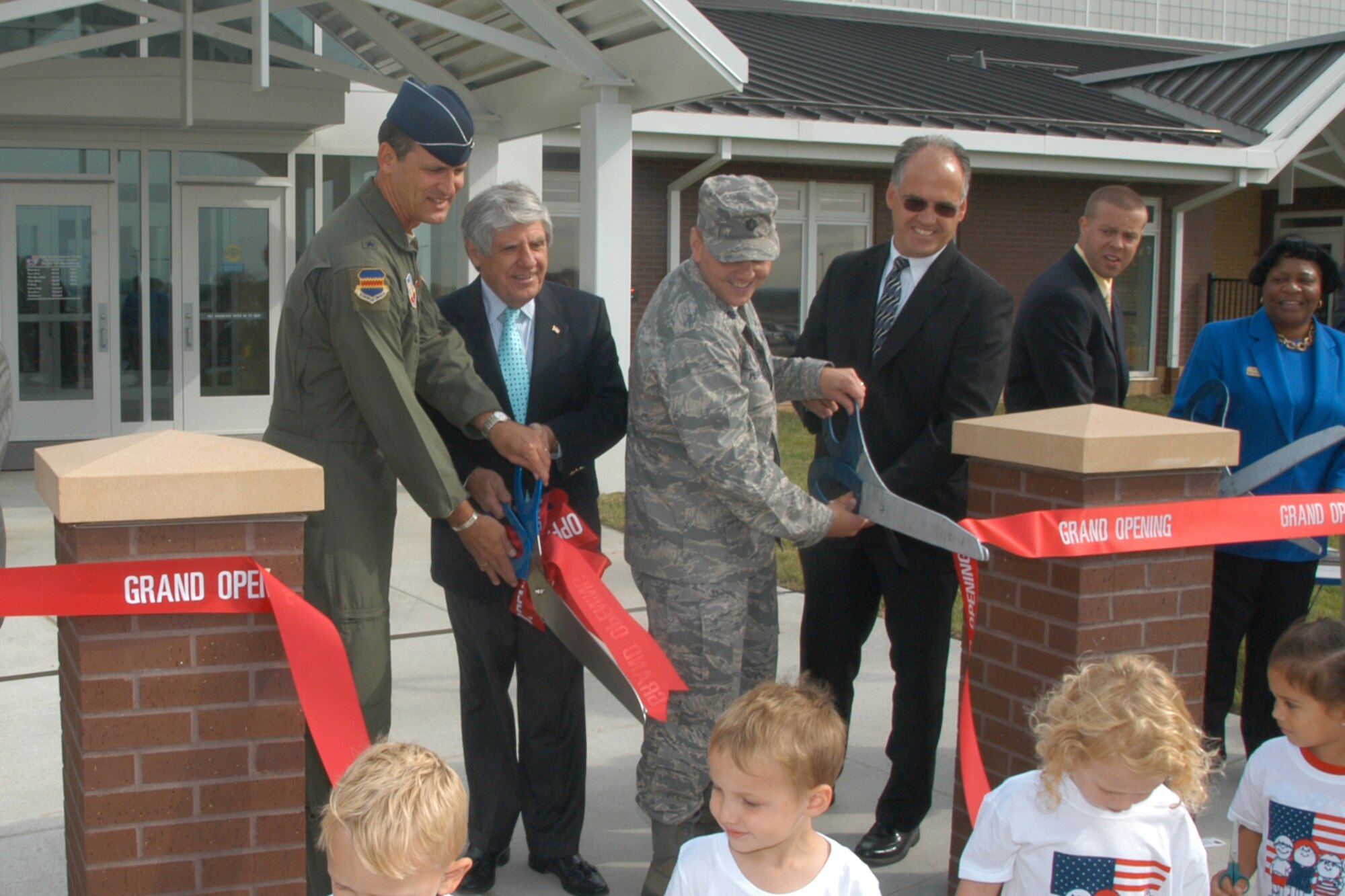 Brig. Gen. James J. Jones, 55th Wing commander; Nebraska Sen. Benjamin Nelson and Lt. Col. Jeffrey Pearson, 55th Force Support Squadron commander; and John Kundinger, 55th Mission Support Group director, take the first cut at the official ribbon cutting ceremony Sept. 2 at the new child development center at Offutt. (U.S. Air Force Photo By/Jeff Gates) 