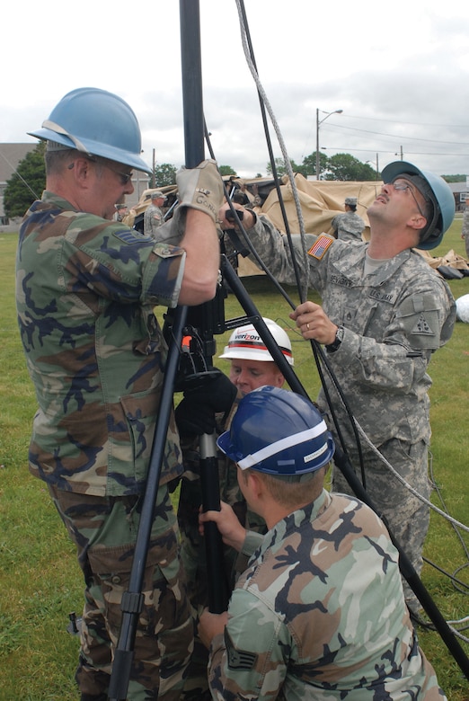 Connecticut Air and Army National Guard members anchor the antennae tower of the Joint Incident Site Communication Capability (JISCC) system. The JISCC allows global communication between federal, military, state and local authorities. (Clockwise from Left) Staff Sgt. Christopher P. Manner, 103rd Communication Squadron, Master Sgt. Gary M. Goncalo, 103rd Air Control Squadron, Staff Sgt. Ted Sevigny, Joint Forces Headquarters, and Staff Sgt. Tyler R. Waterman 103rd Air Operations Group work together to ensure the stability of the JISCC  tower on June 5, 2008, during a training deployment to Camp Rell, Niantic, Connecticut.  (U.S. Air Force photo by Staff Sgt. Nicholas A. McCorkle) 
