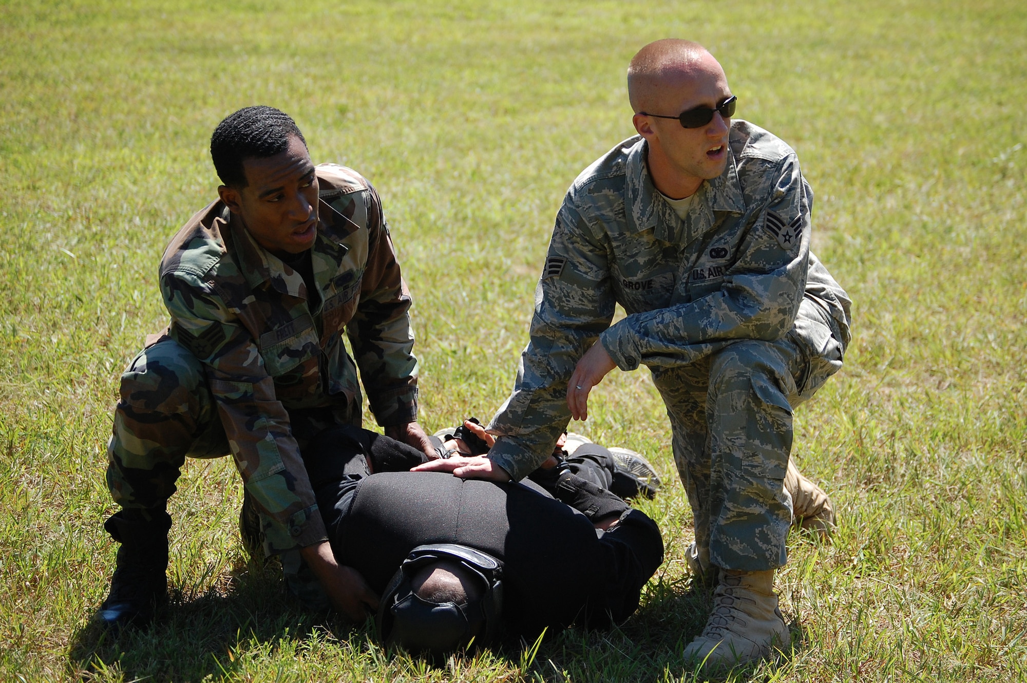 Senior Airmen Ashton Frett and Ryan Grove, both students in the Air Force Phoenix Raven Training Course, subdue an "agressor" during an evaluation session in the course Aug. 20, 2008, on a Fort Dix, N.J., range.  The Raven course, taught by the U.S. Air Force Expeditionary Center on Fort Dix, N.J., teaches specialized training for security forces Airmen in areas such as aircraft security, self defense and verbal communication.  Airman Frett is from the 305th Security Forces Squadron at McGuire Air Force Base, N.J., and Airman Grove is from the 436th Security Forces Squadron at Dover AFB, Del.  (U.S. Air Force Photo/Tech. Sgt. Scott Mueller)