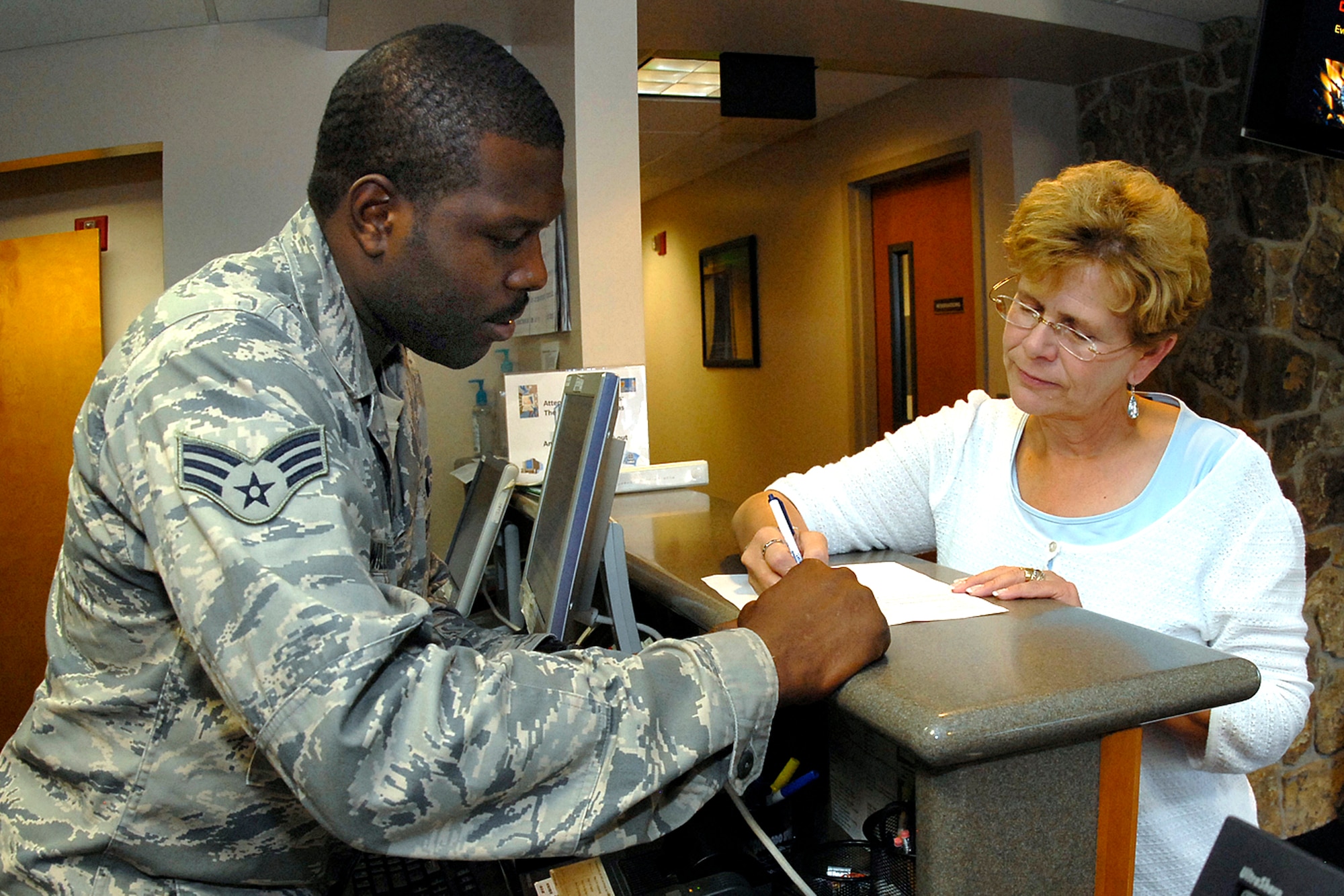 Senior Airman Cory Williams assists Donna Burrill, 21st Force Support Squadron marketing office, in the daily lodging operations. Airman Williams was selected for the First Knight award for the week of Sept. 4, 2008. This award is designed to recognize outstanding Airmen each week for the work they do each day. (U.S. Air Force photo/Rob Bussard) 