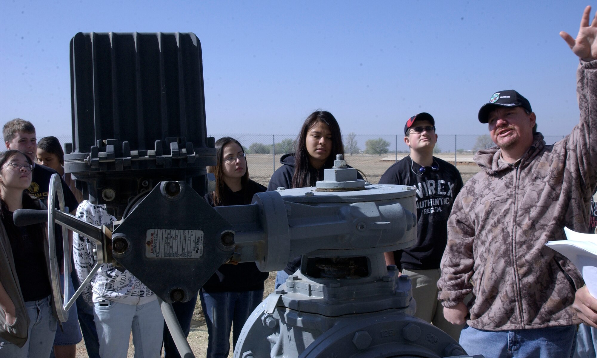 CANNON AIR FORCE BASE, N.M.-- Jesse Frogge, an employee at the 27th Special Operations Wing Waste Water Treatment Plant, explains to Clovis High School students how the automatic influent valve controls water flow through two basins. When a basin is opened, influents flood into the sequencing batch reactor, where microorgansims treat the waste water. (U.S. Air force photo/Airman Maynelinne De La Cruz)  