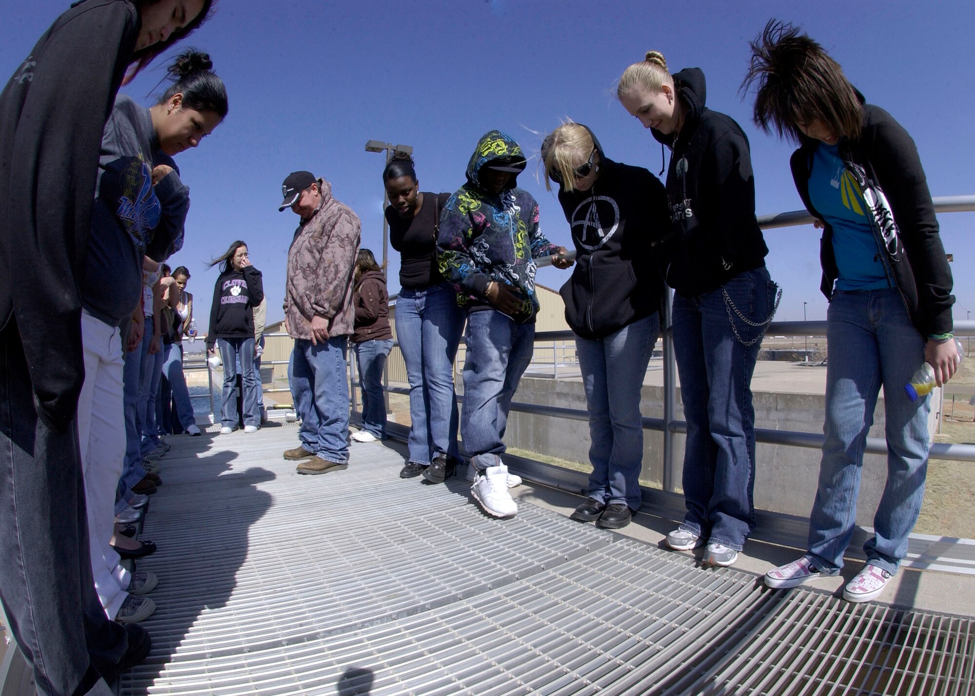 CANNON AIR FORCE BASE, N.M.-- Clovis High School students watch as water rushes underneath them Apr. 22 at the 27th Special Operations Wing Waste Water Treatment Plant. After the water is chlorinated in the contact chamber, it passes through the effluent parshall flume where the water is released into the Playa Lake. (U.S. Air Force photo/Airman Maynelinne De la Cruz)   