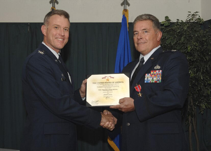 DYESS AIR FORCE BASE, Texas -- Colonel Robert F. Gass, 7th Bomb Wing commander, presents the Bronze Star Medal to Col.James D. Milburn,  7th Maintenance Group commander, at the Hangar Center here, Aug. 27 for his outstanding leadership during his tour in Southwest Asia in support of the Global War on Terrorism . (U.S. Air Force Photo/Airman 1st Class Stephen Reyes)