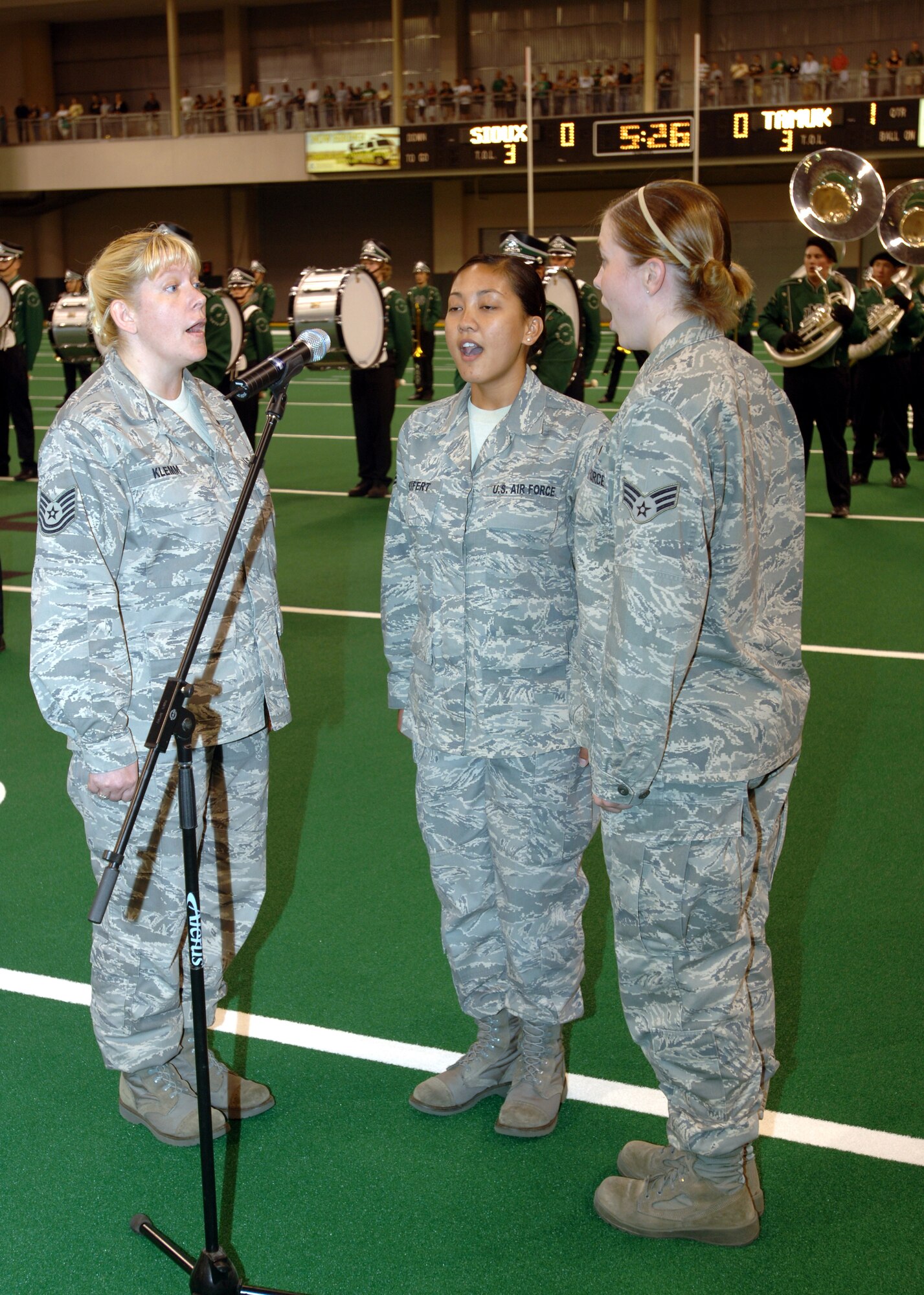 Tech. Sgt. Christine Klemm (L), 319th Medical Operations Squadron; Senior Airman Kassandra Seifert (C), 319th Medical Support Squadron and Senior Airman Faith Walker (R), 319th Force Support Squadron sing the national anthem before the kickoff of the University of North Dakota football season Aug. 28.  UND and the Grand Forks community named the day Military Appreciation Day and was marked by performances by the Airmen, a rappeling demonstration and the GFAFB honor guard presenting the colors.  After the ceremonies, Airmen, as well as other military members were treated to watching the UND Fighting Sioux football team beat the Javalinas of Texas A&M Kingsville in their first Division 1 game. (U.S. Air Force photo/Tech. Sgt. Joseph Kapinos)