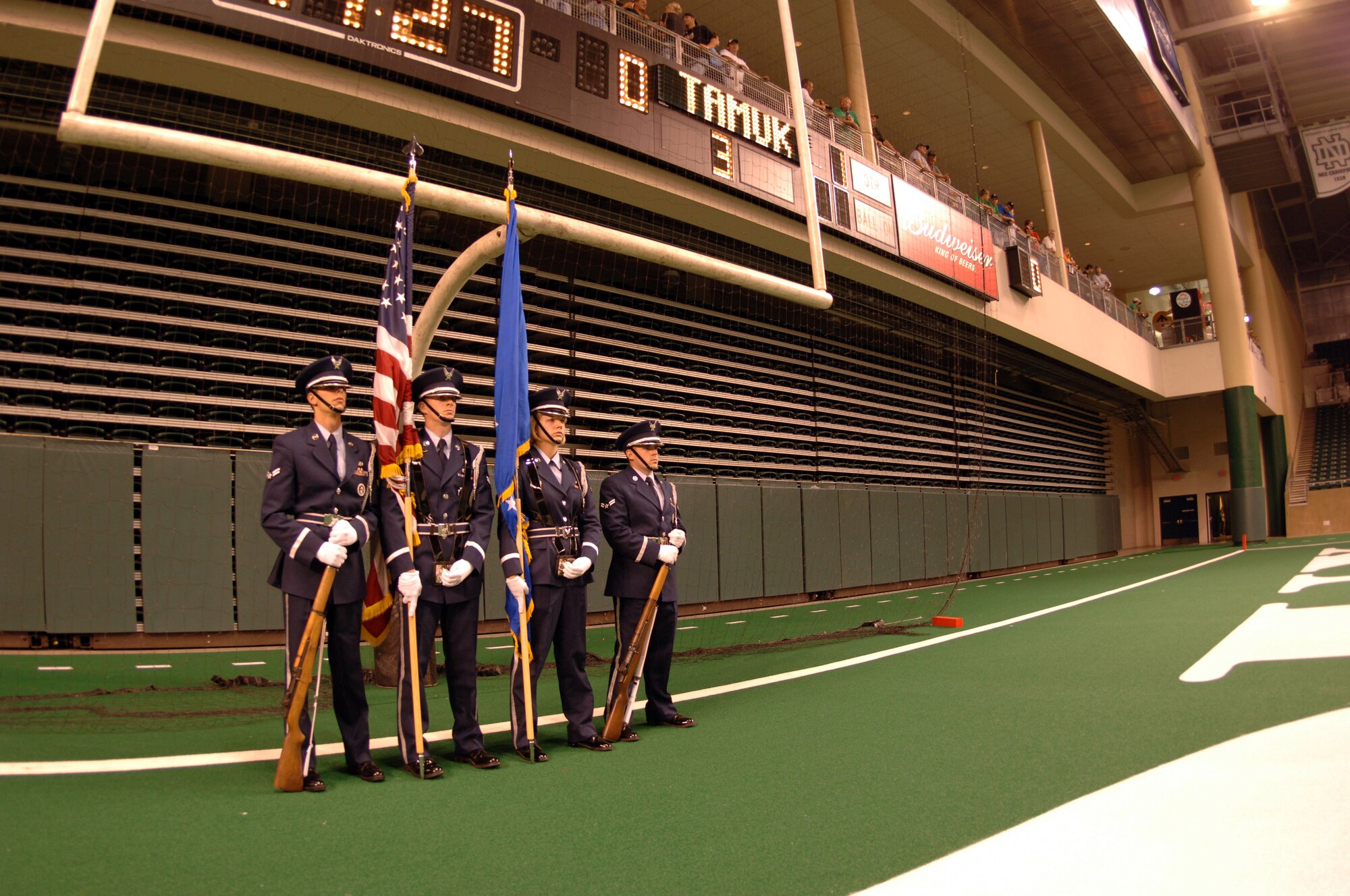 Grand Forks Air Force Base honor guard members stand ready to present the colors during the opening ceremonies during Military Appreciation Day, Aug. 28, at the Alerus center in Grand Forks, N.D. The presentation was done prior to the start of the University of North Dakota football season which had the UND Fighting Sioux taking on the Javalinas of Texas A&M Kingsville.  The members of the Honor Guard are (Left to right) Airman First Class Jacob Converse, 319th Civil Engineer Squadron; Airman First Class Jason Tinkham, 319th Logistics Readiness Squadron; Airman First Class Malinda Sowards, 319th Contracting Squadron and Airman First Class Jeff Deaveiro, 319th Operations Support Squadron. (U.S. Air Force photo/Tech. Sgt. Joseph Kapinos)