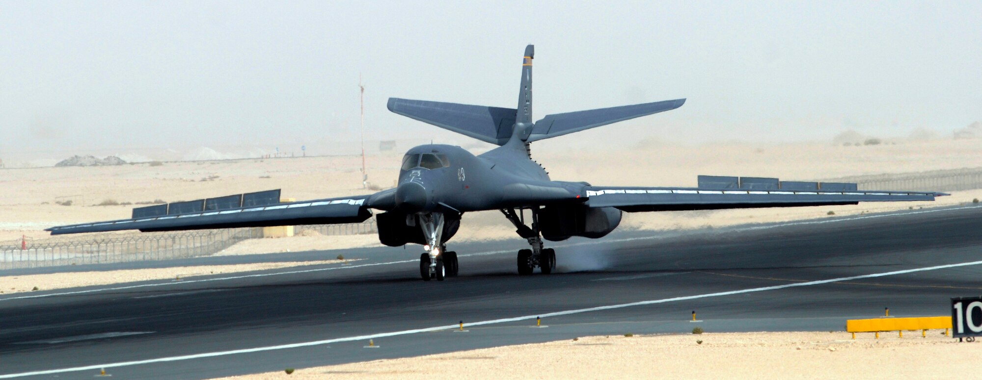 A B-1B Lancer goes full flaps and hits the brakes to stop after completing another combat mission Sep. 2, 2008. The B-1 is deployed from Ellsworth Air Force Base, S.D., to an undisclosed air base in support of Operations Iraqi and Enduring Freedom. Carrying the largest payload of both guided and unguided weapons in the Air Force inventory, the multi-mission B-1 is the backbone of America's long-range bomber force. It can rapidly deliver massive quantities of precision and non-precision weapons against any adversary, anywhere in the world, at any time.  (U.S. Air Force photo by Tech. Sgt. Michael Boquette/Released)